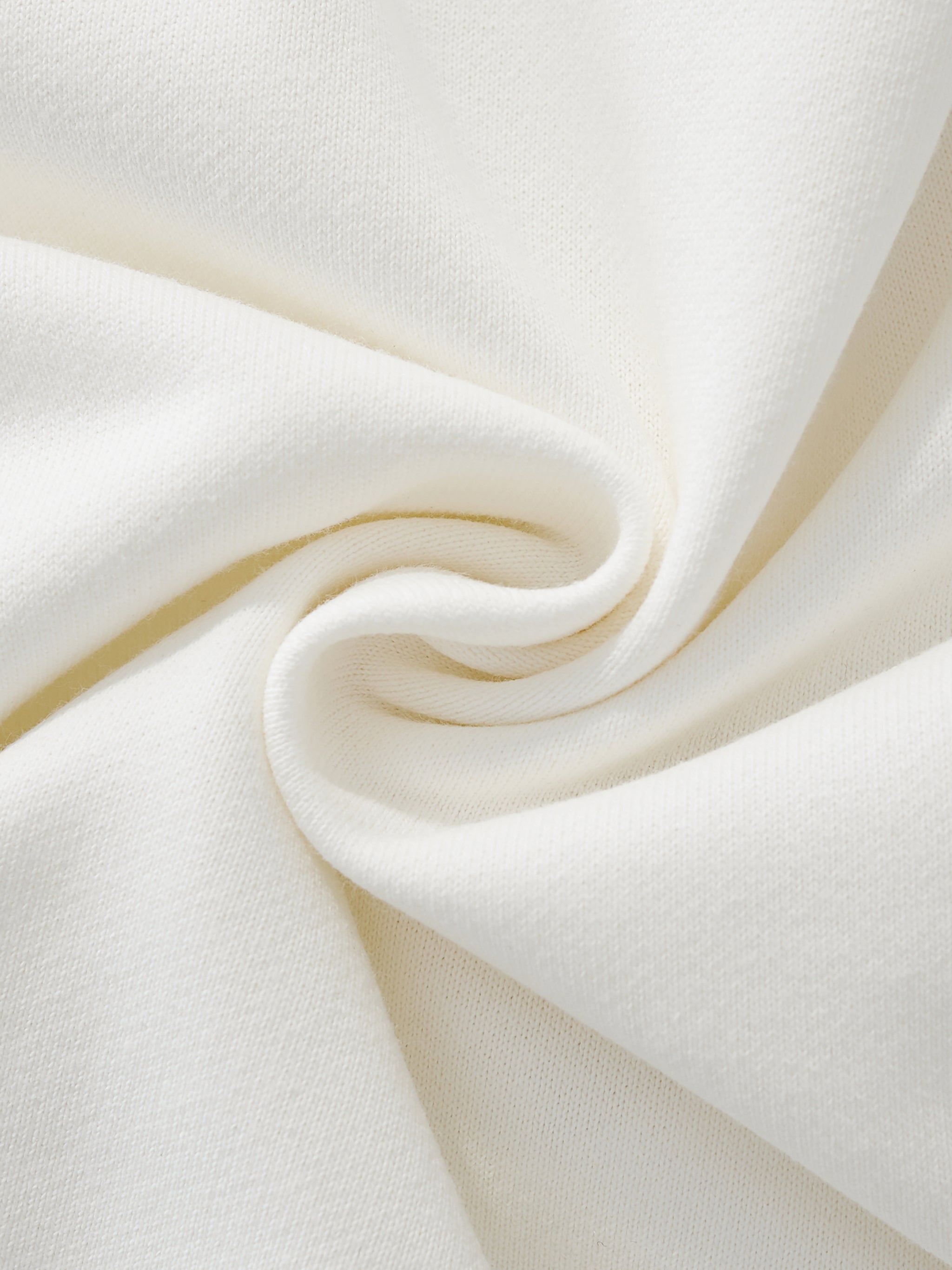 Close-up of soft heavyweight cream sweatshirt fabric with textured knit surface.