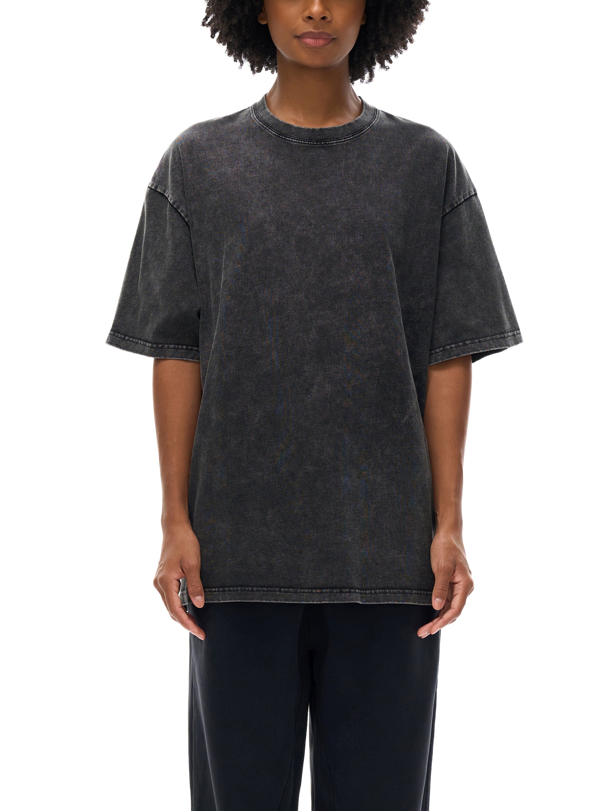 Woman wearing oversized snow-washed black cotton T-shirt with relaxed fit.