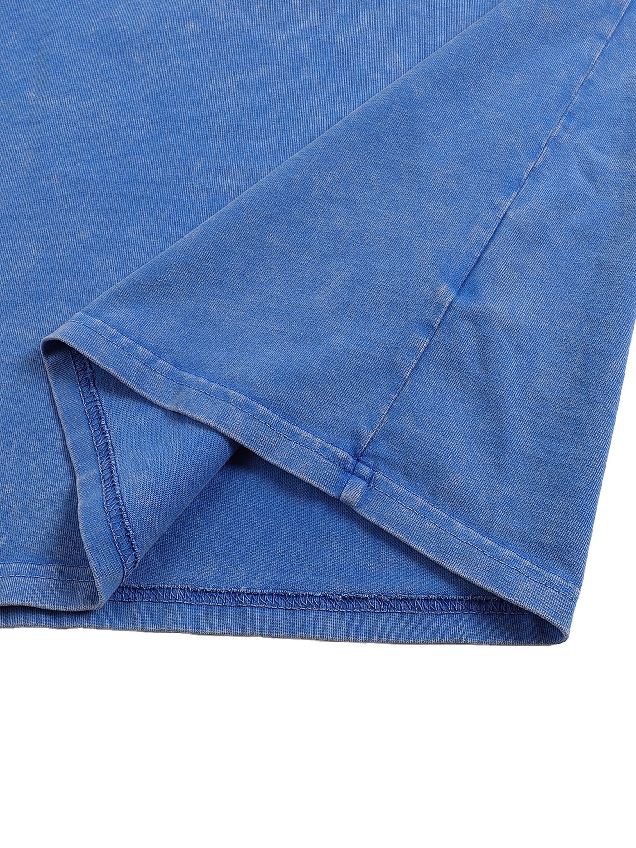 Close-up of blue snow-washed oversized cotton T-shirt sleeve with visible stitching.