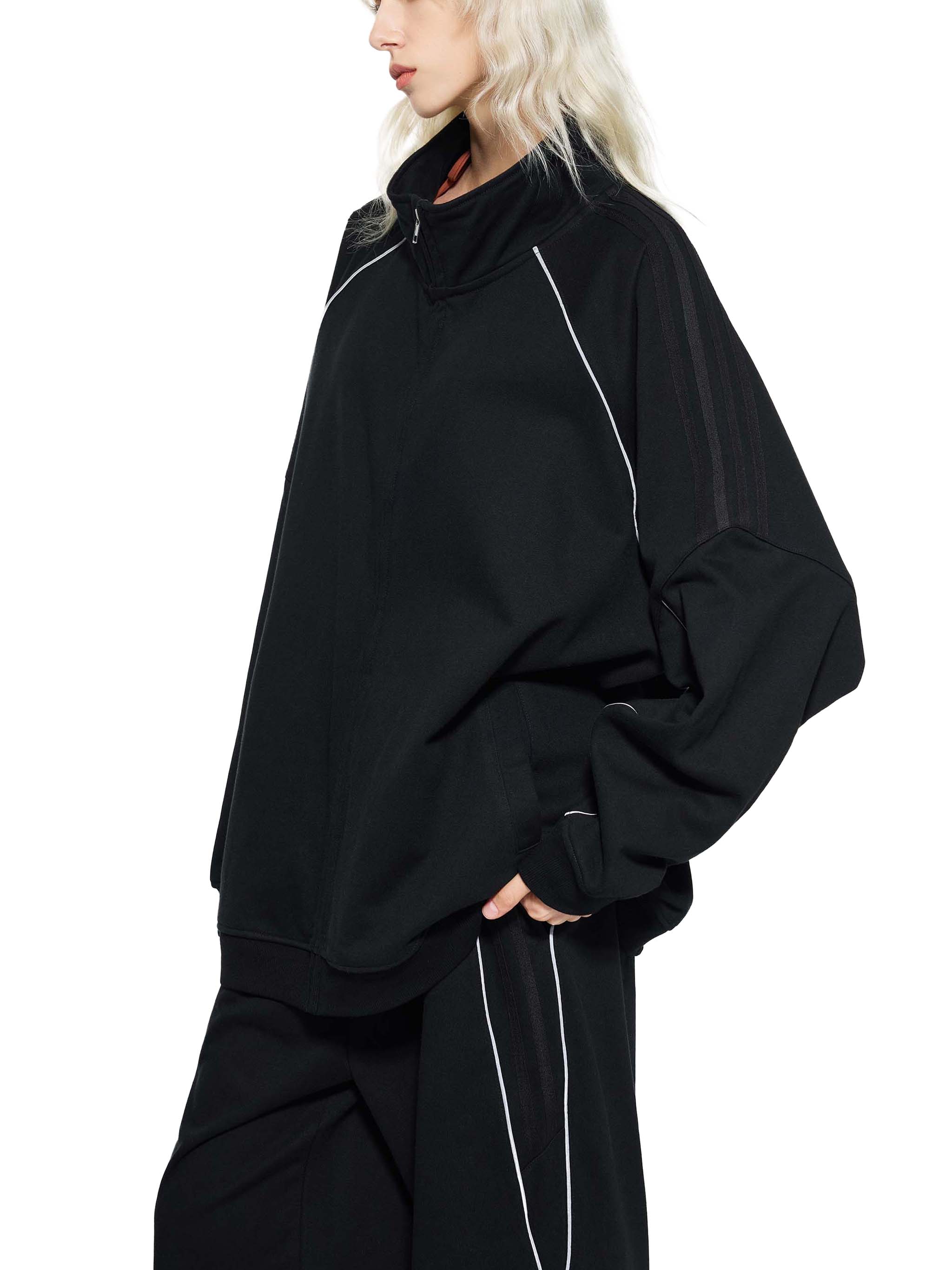 Black oversized raglan sleeve jacket with subtle stripes and white piping, streetwear style