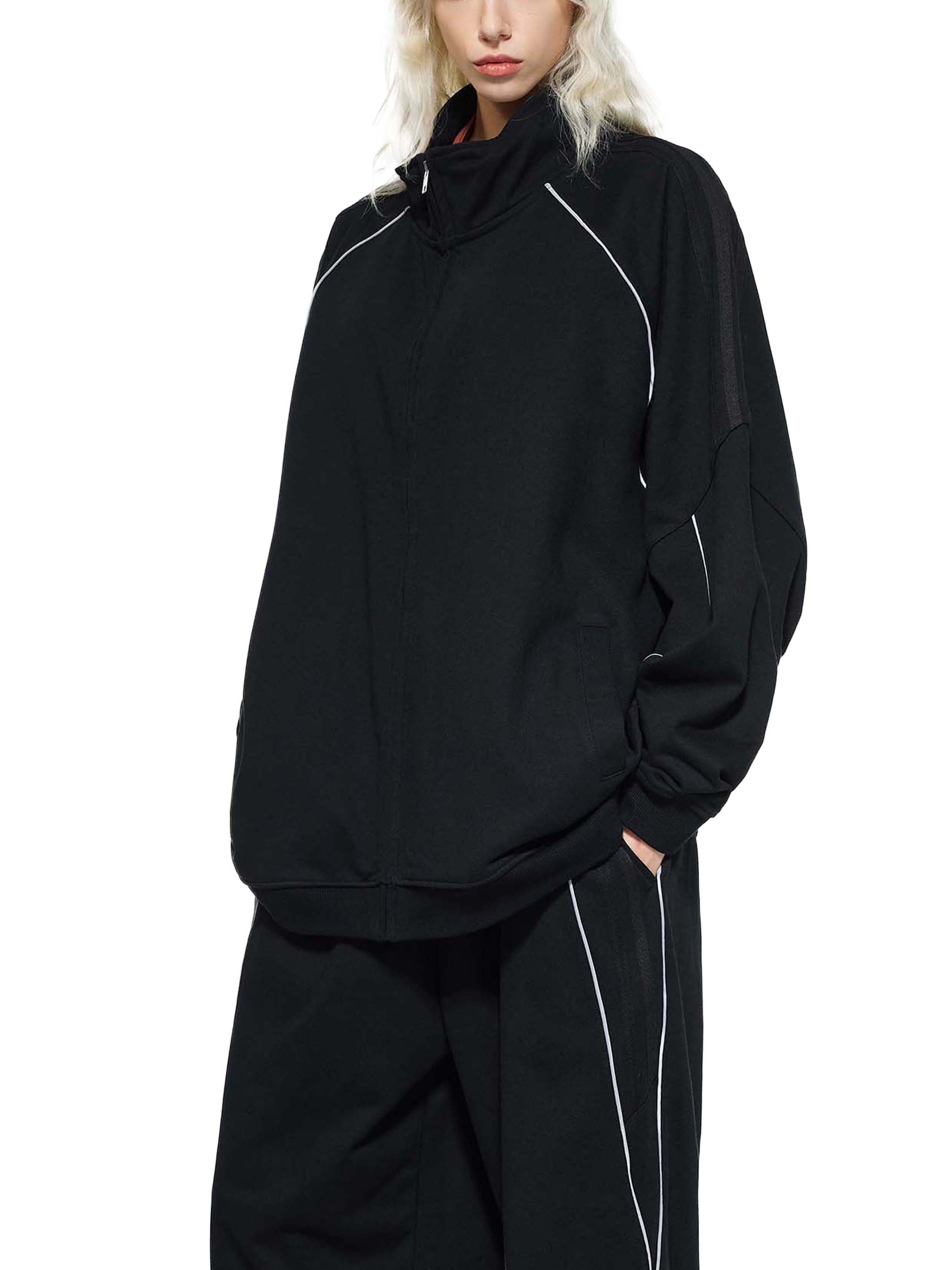 Black raglan sleeve jacket with white reflective stripes, relaxed fit streetwear style