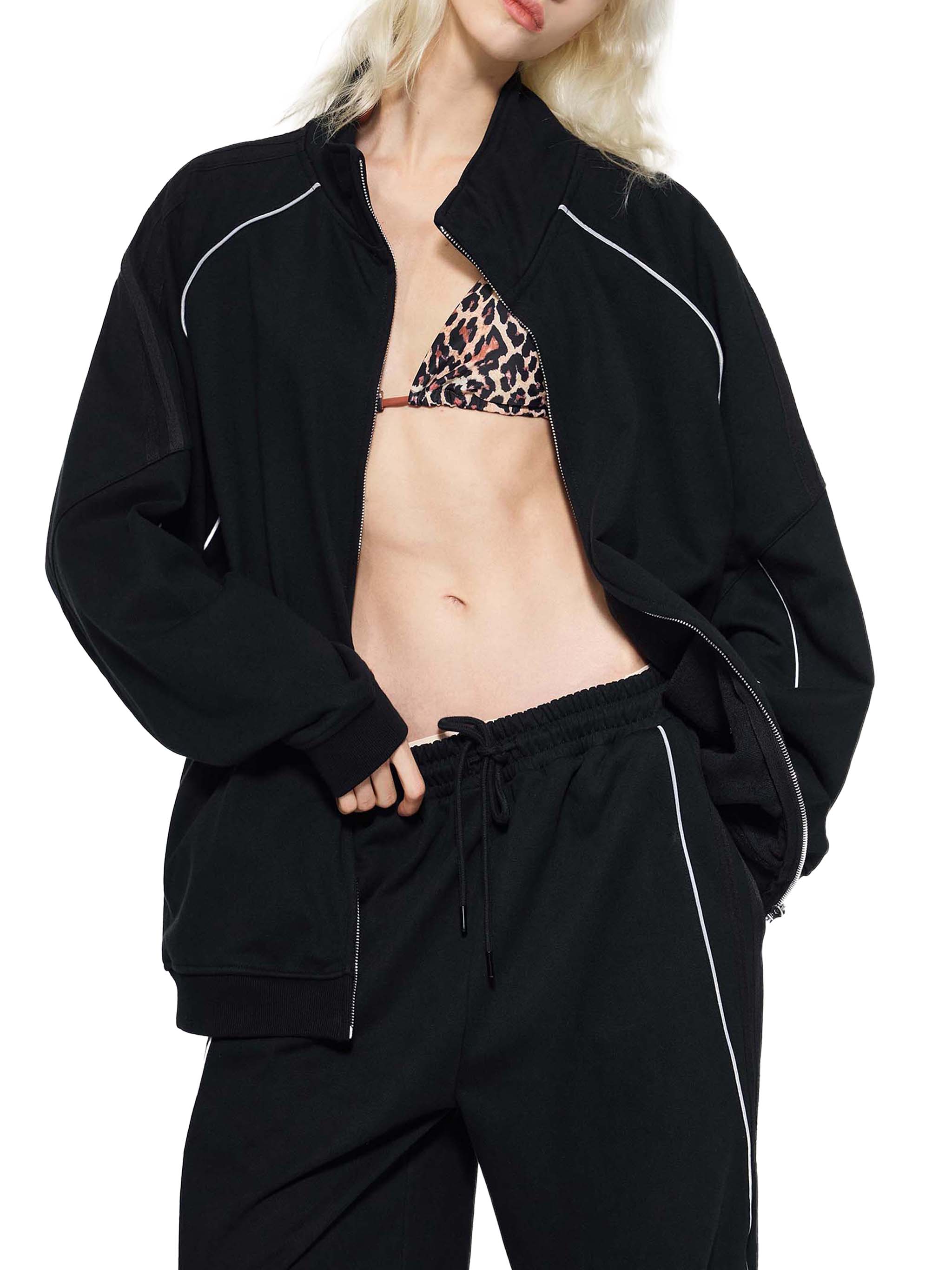 Woman wearing black striped raglan sleeve jacket with matching joggers and animal print bikini top