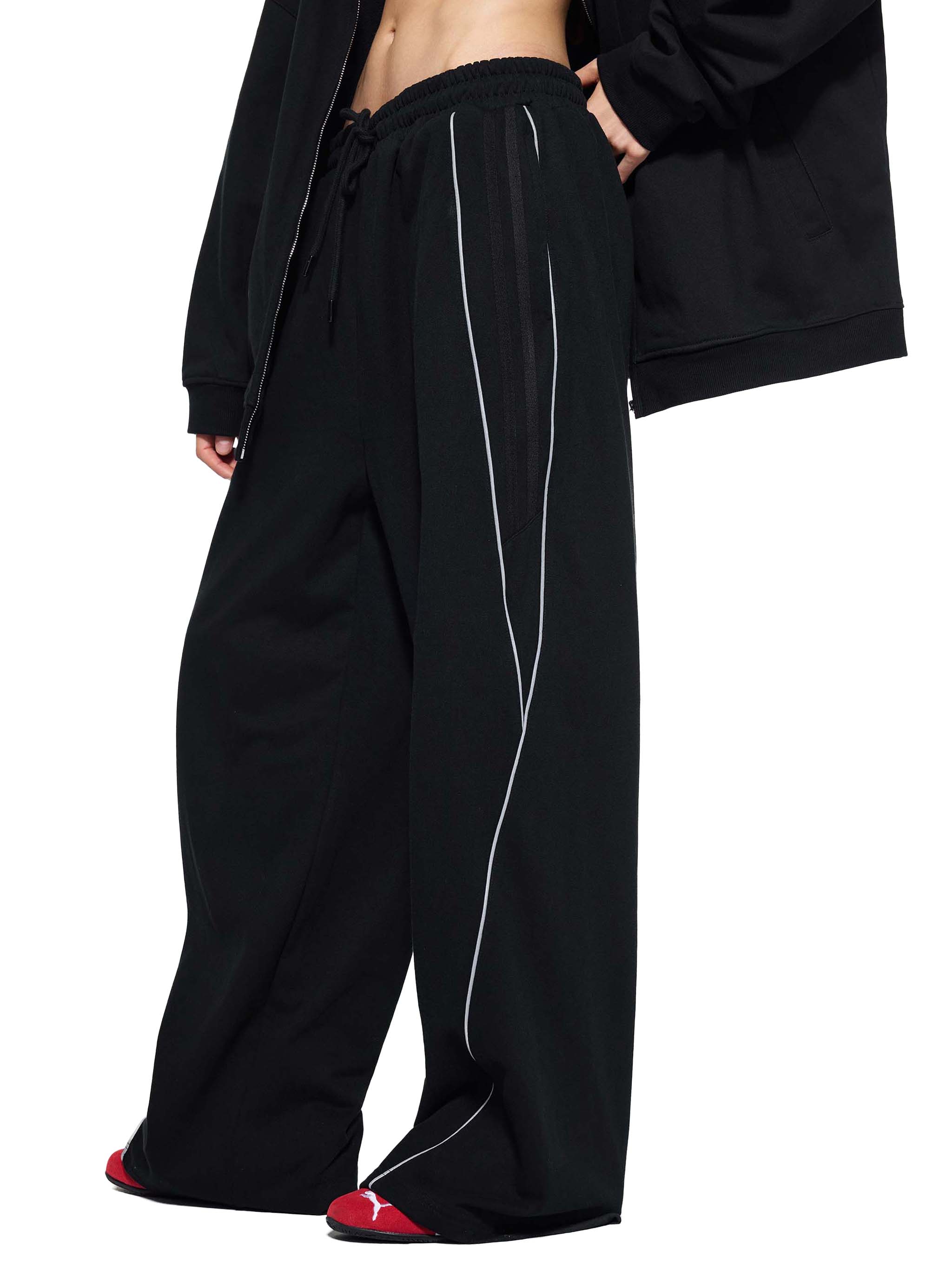 Black straight-leg sweatpants with white side stripes and relaxed fit