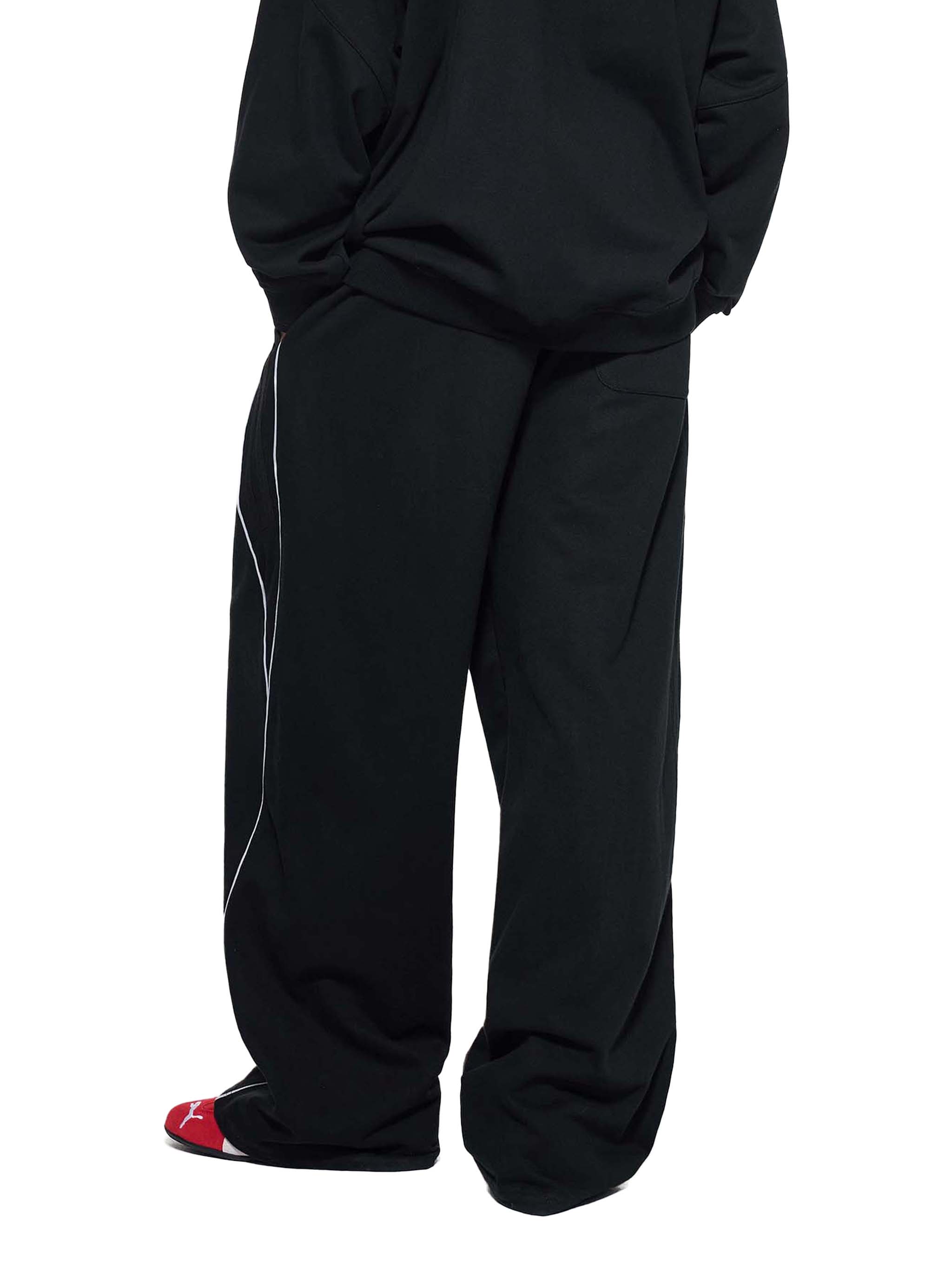 Black straight-leg sweatpants with side reflective stripe, relaxed fit, streetwear style.