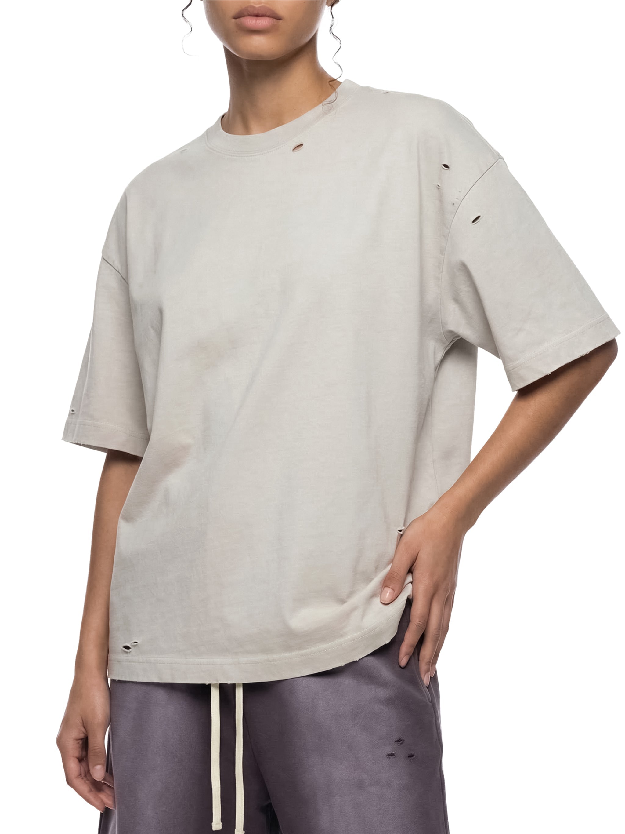Model wearing a vintage washed, boxy oversized distressed t-shirt and relaxed fit shorts.