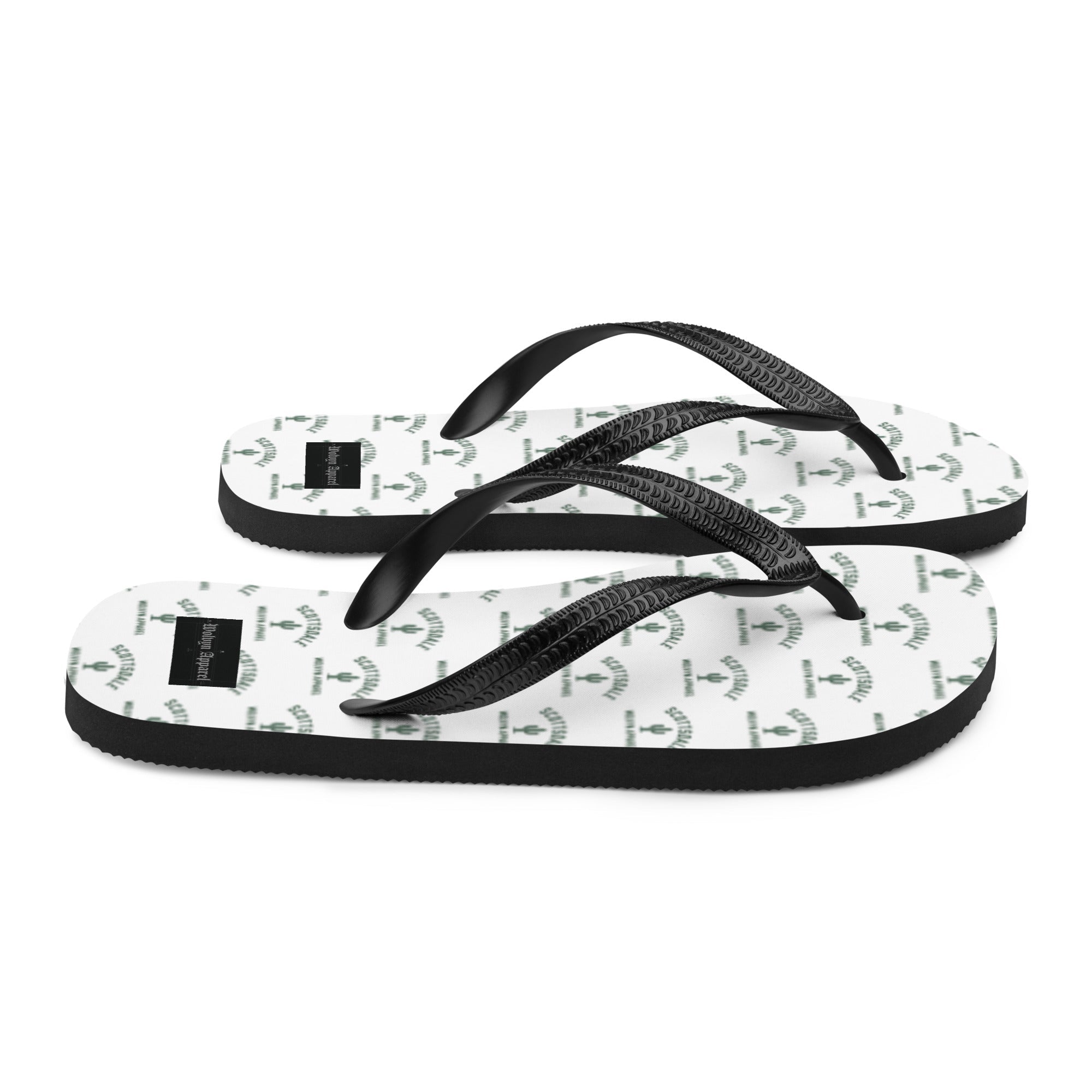 White and black flip flops with cactus graphic pattern and black textured straps on white background