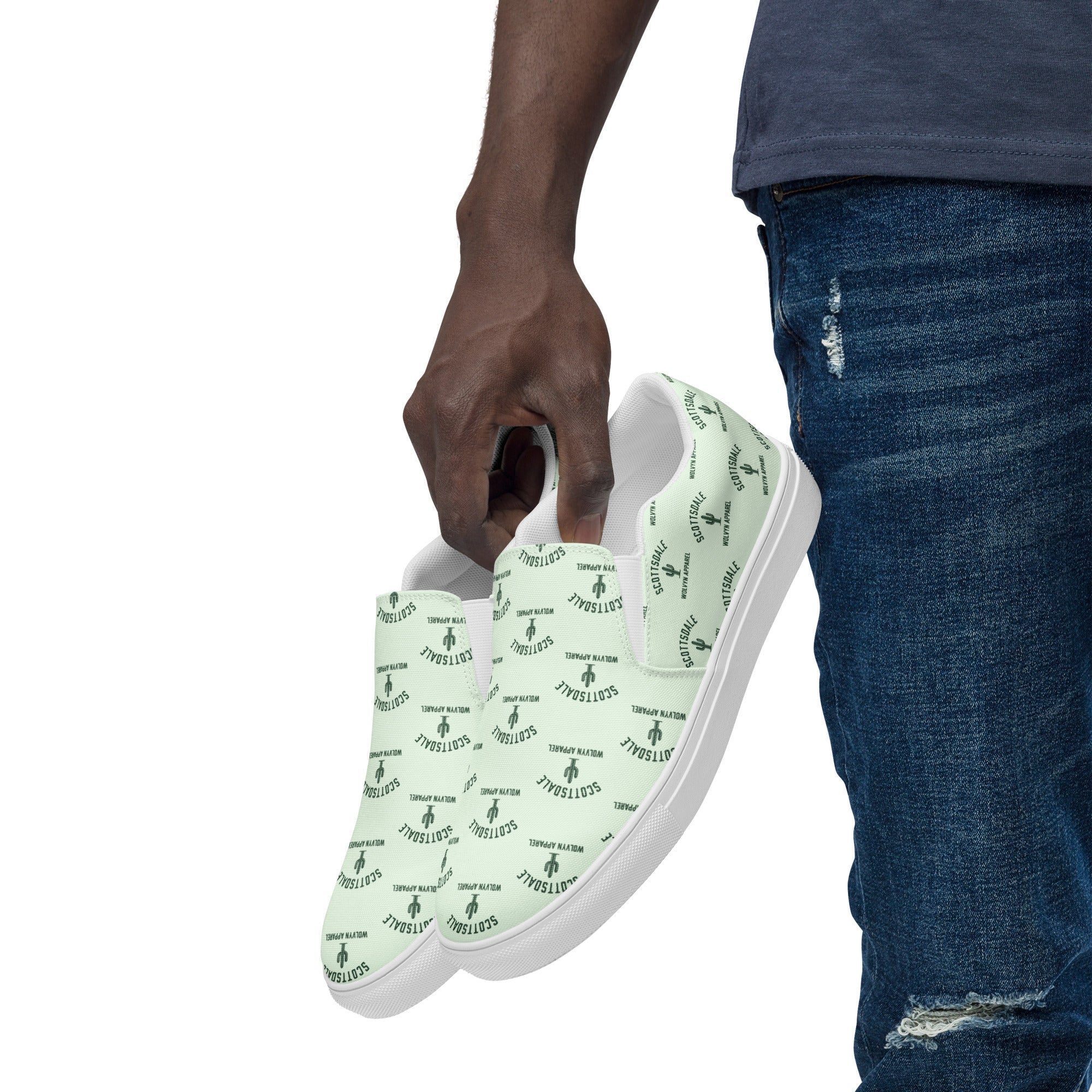 Man holding mint green slip-on canvas shoes with Scottsdale and graphic print, casual outfit