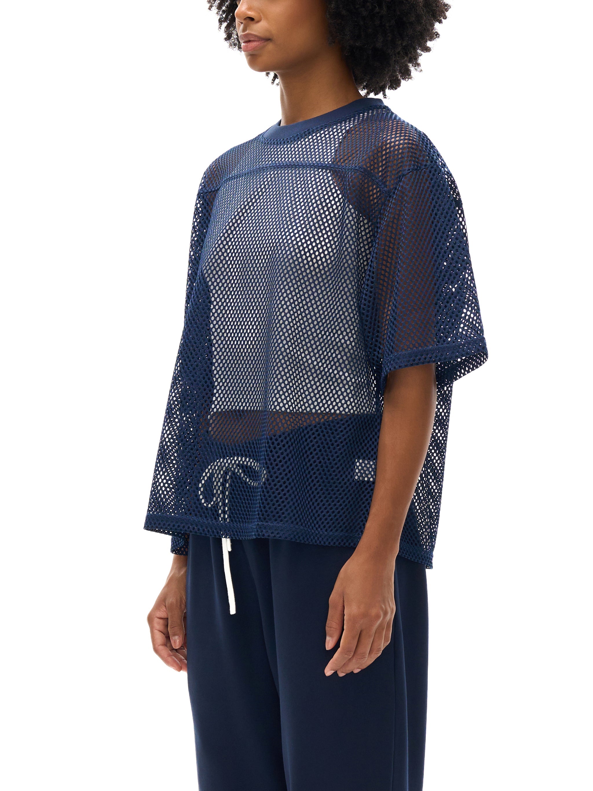 Model wearing navy boxy net t-shirt with mesh see-through design and relaxed fit.