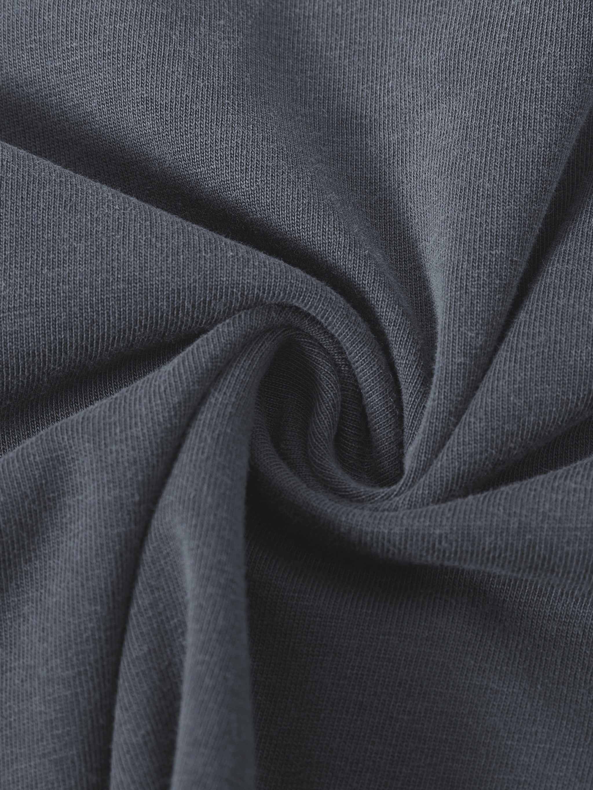 Closeup of heavyweight vintage washed dark gray cotton t-shirt fabric texture