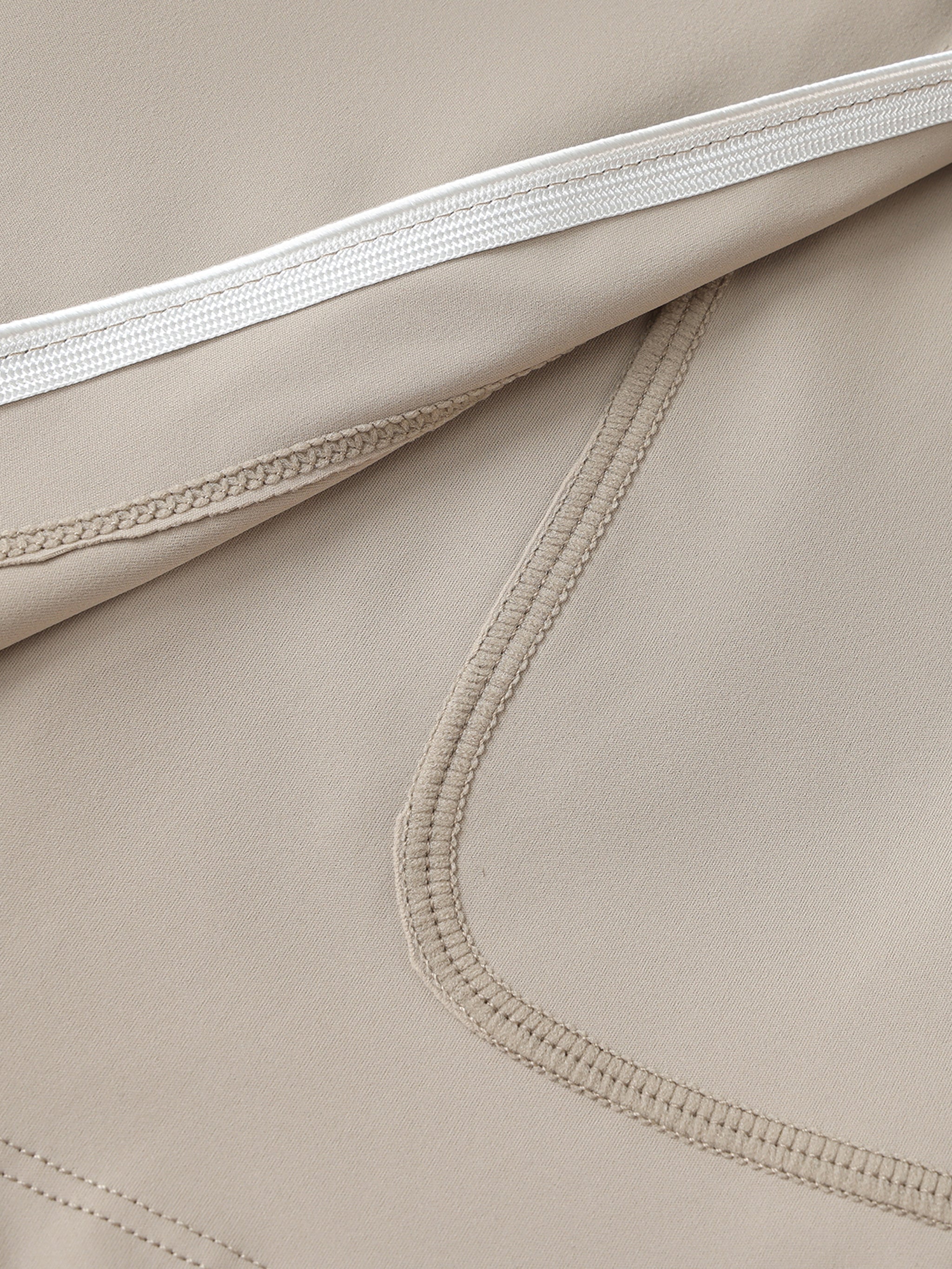 Close-up of beige high-waist A-line skirt with pocket detail and contrast stitching