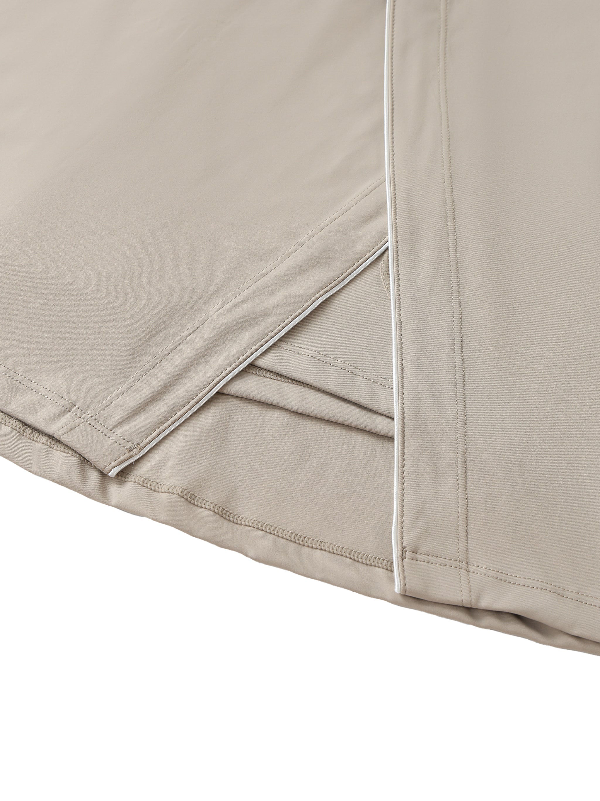 Close-up of beige high-waist A-line skirt with pockets and white trim detail