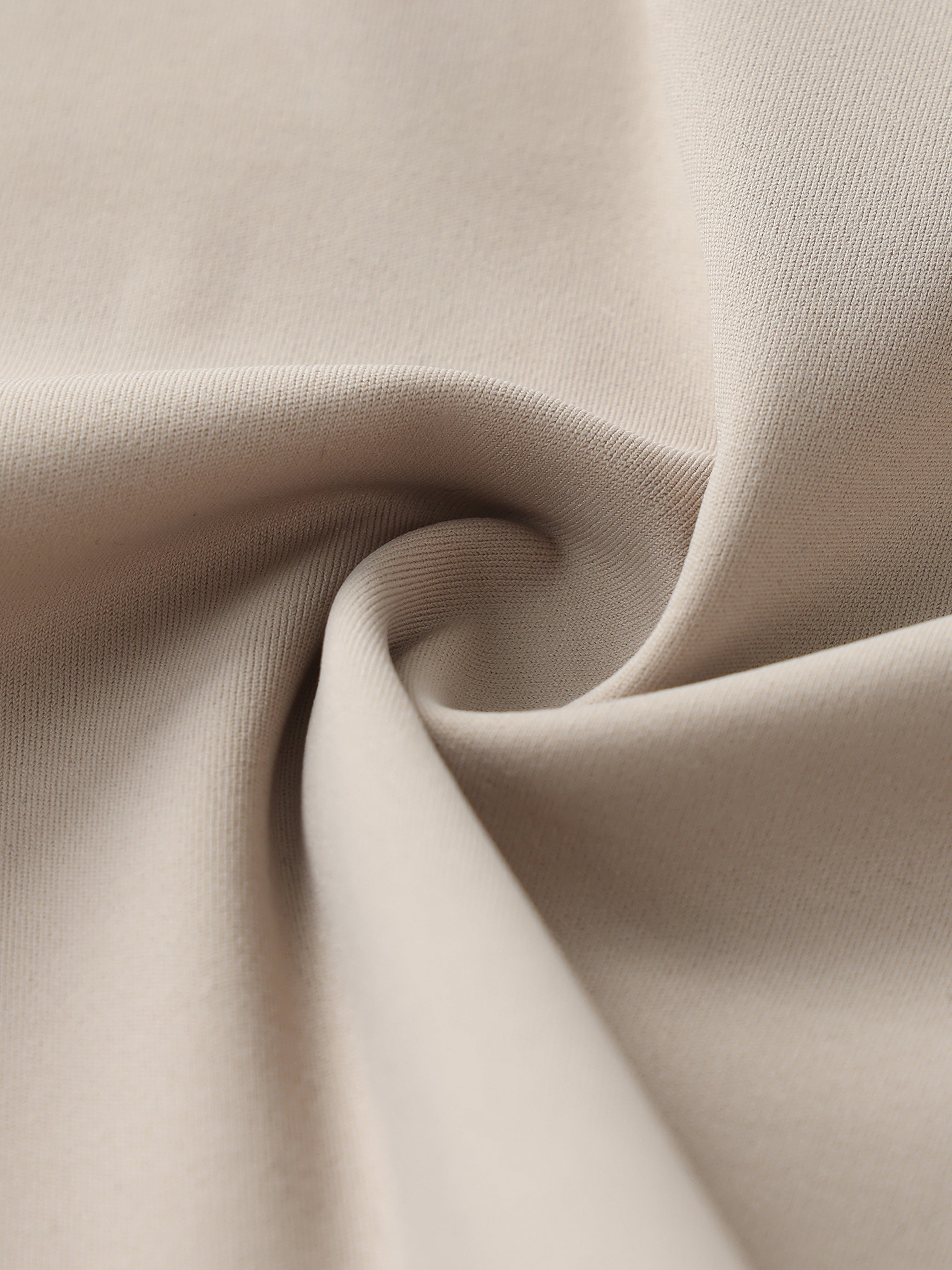 Close-up of beige heavyweight streetwear fabric with soft, premium texture.