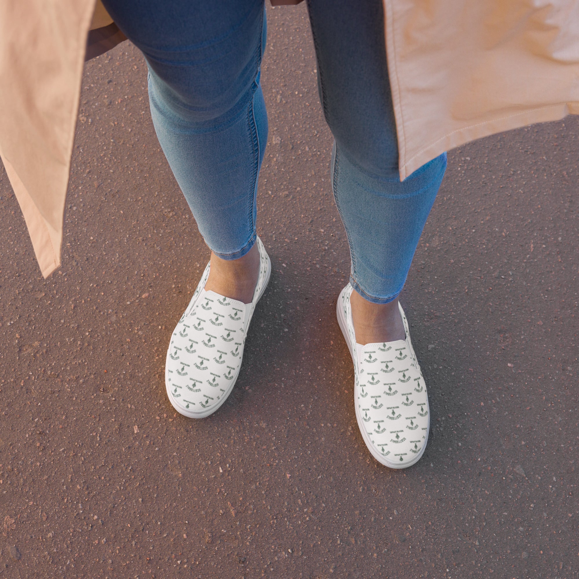 Woman wearing white slip-on canvas shoes with black pattern, standing on pavement