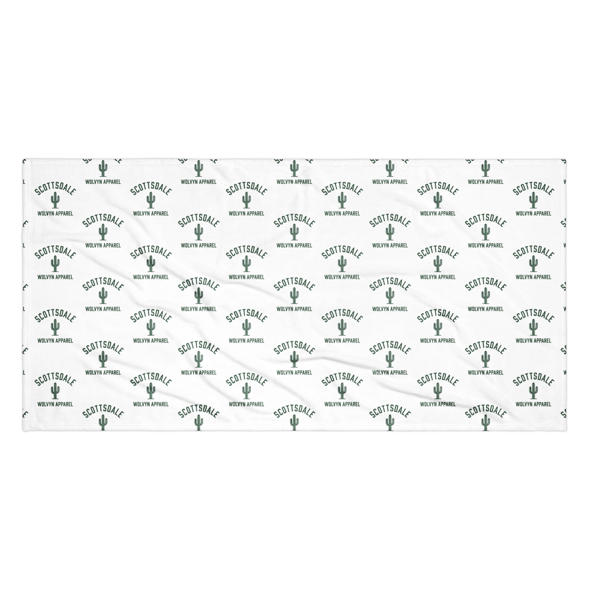 White towel with green Scottsdale text, cactus icons, and repeating Wolvyn Apparel logo pattern.