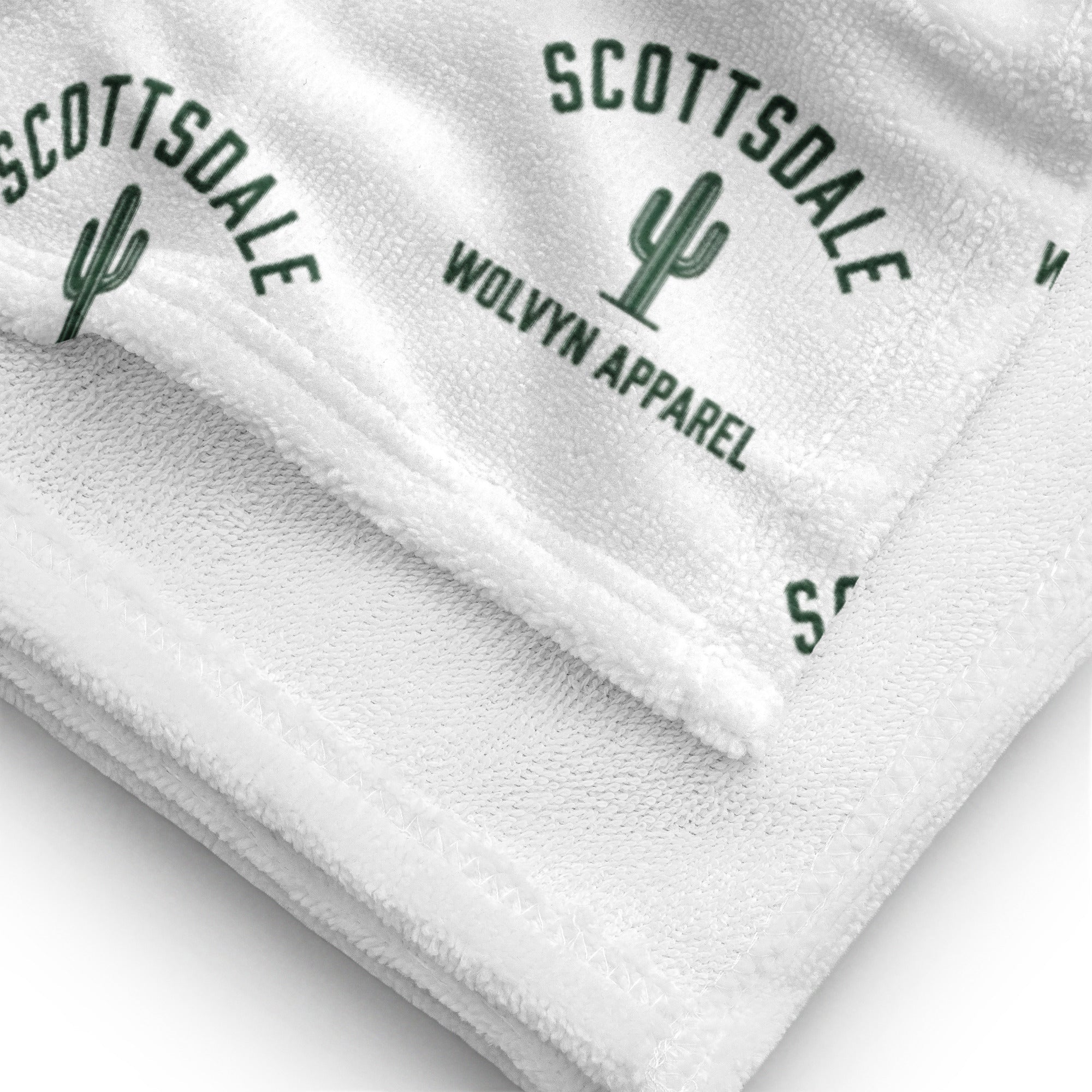 White towel with Scottsdale cactus and Wolvyn Apparel logo, close-up texture view.