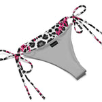 Snow leopard print string bikini bottom with pink accents and tie sides on white background