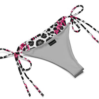 Snow leopard print string bikini bottom with pink accents and tie sides on white background