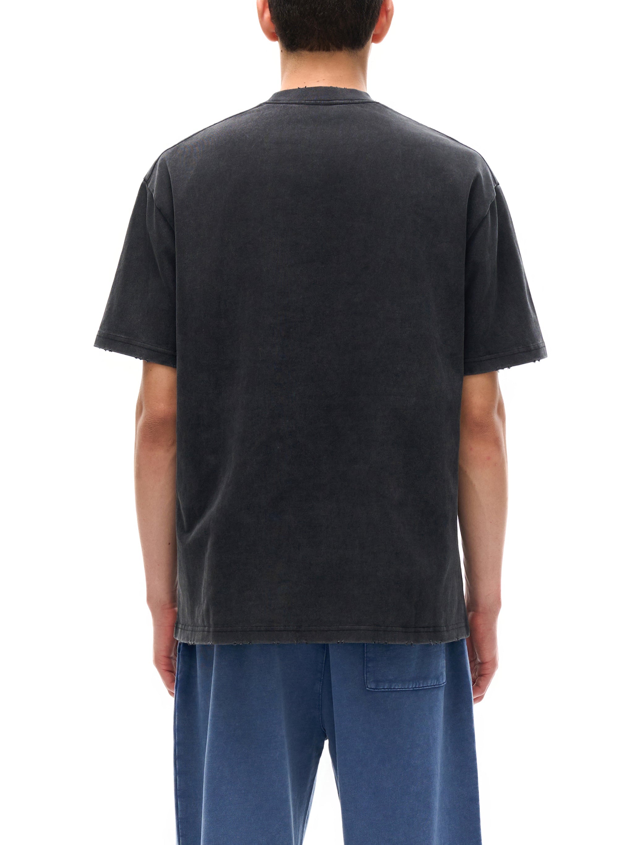 Back view of a heavyweight vintage washed black t-shirt with frayed hems on a person