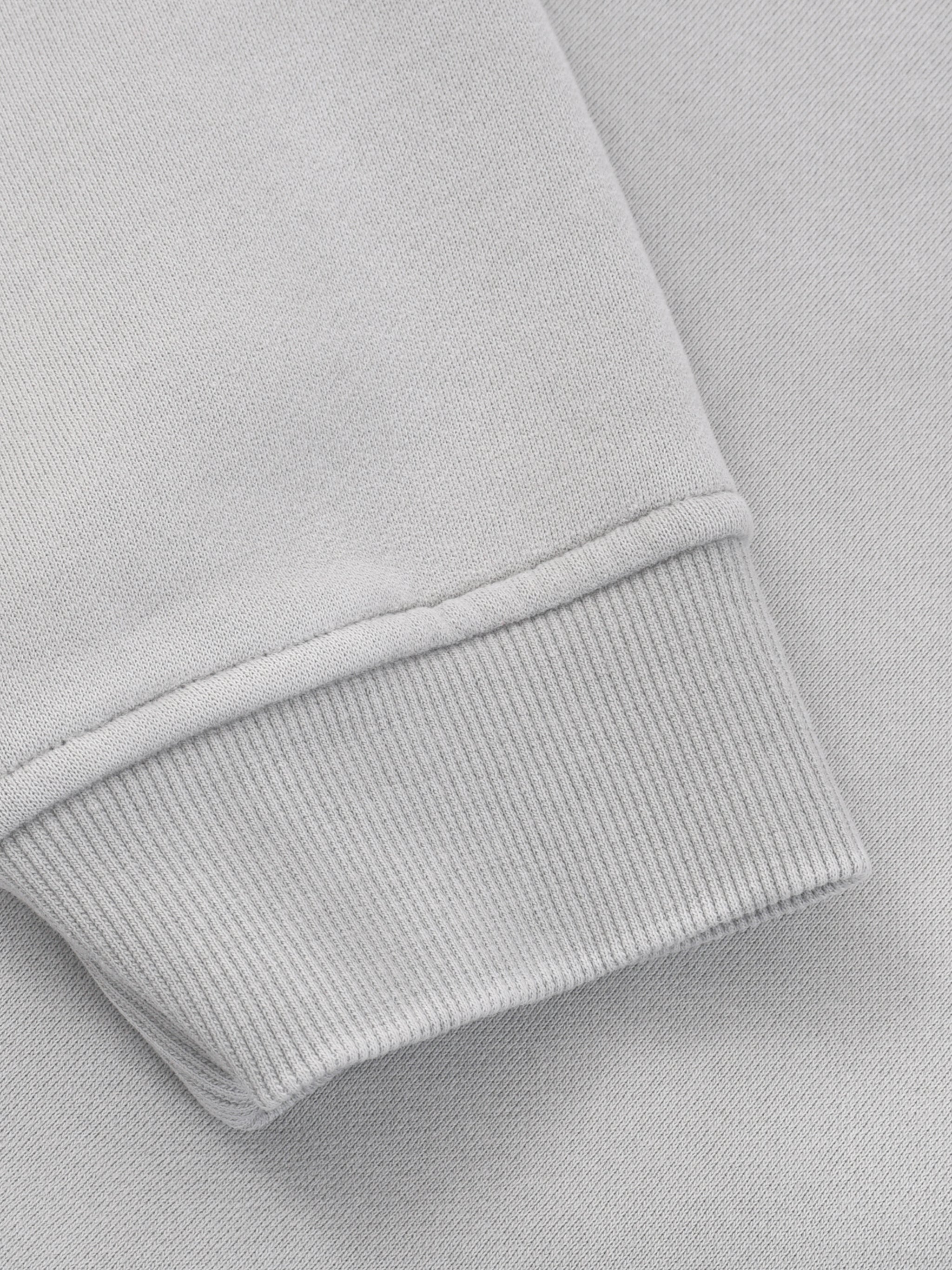 Close-up of light grey heavyweight fleece hoodie sleeve with ribbed cuff detail