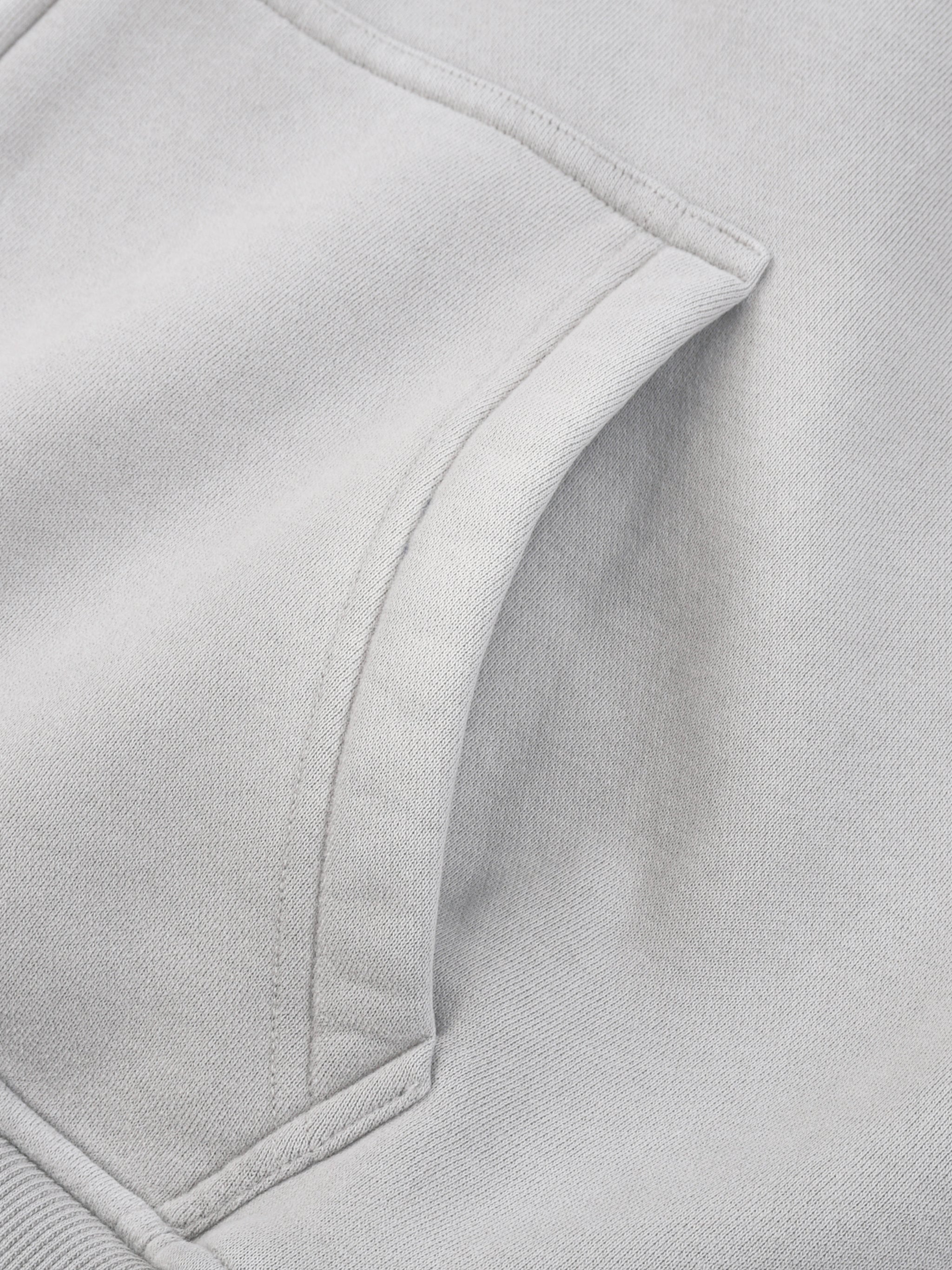 Closeup of a light grey fleece hoodie kangaroo pocket and soft heavyweight fabric texture
