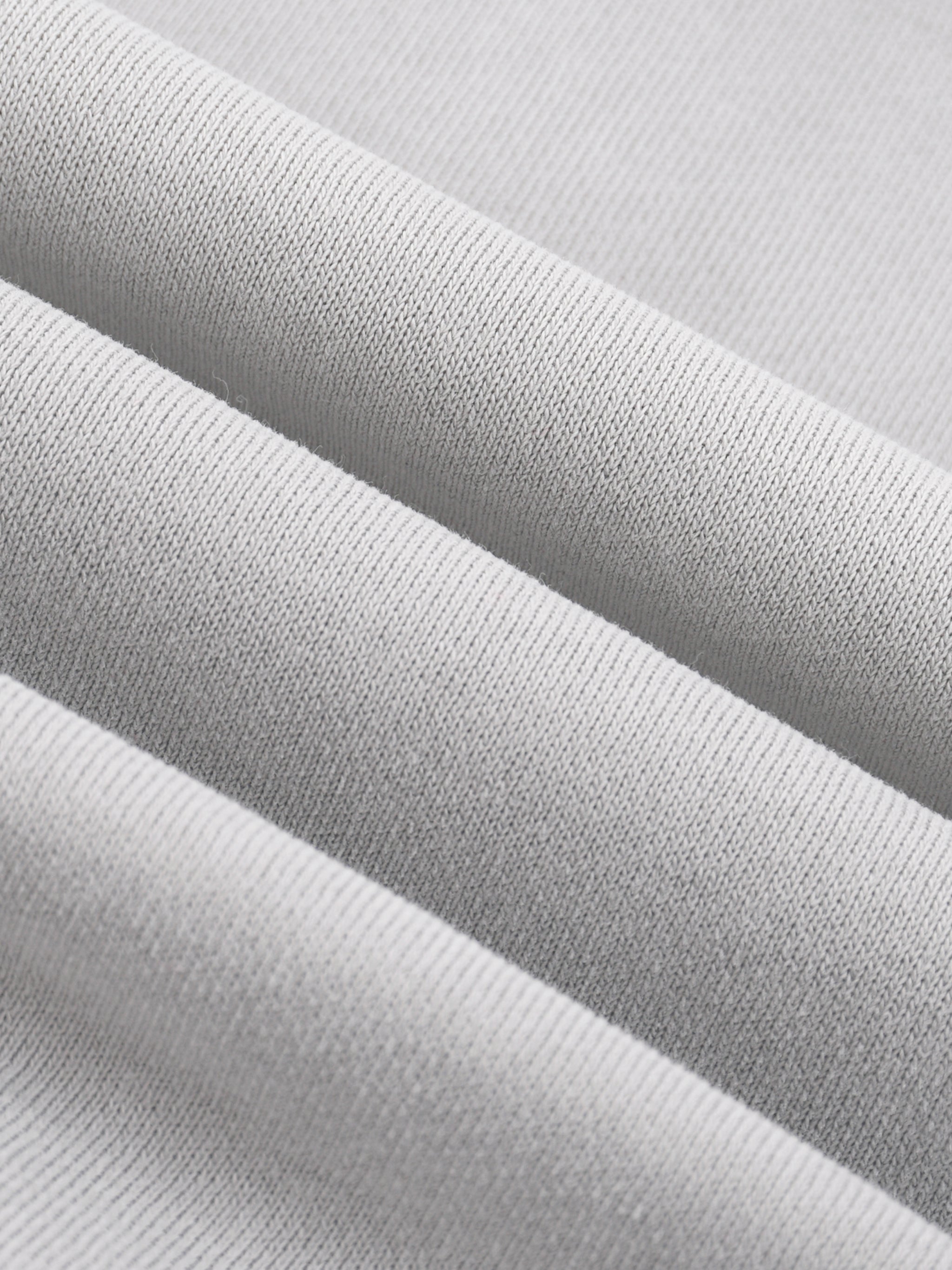 Close-up of heavyweight fleece fabric texture in light grey, ideal for streetwear hoodies