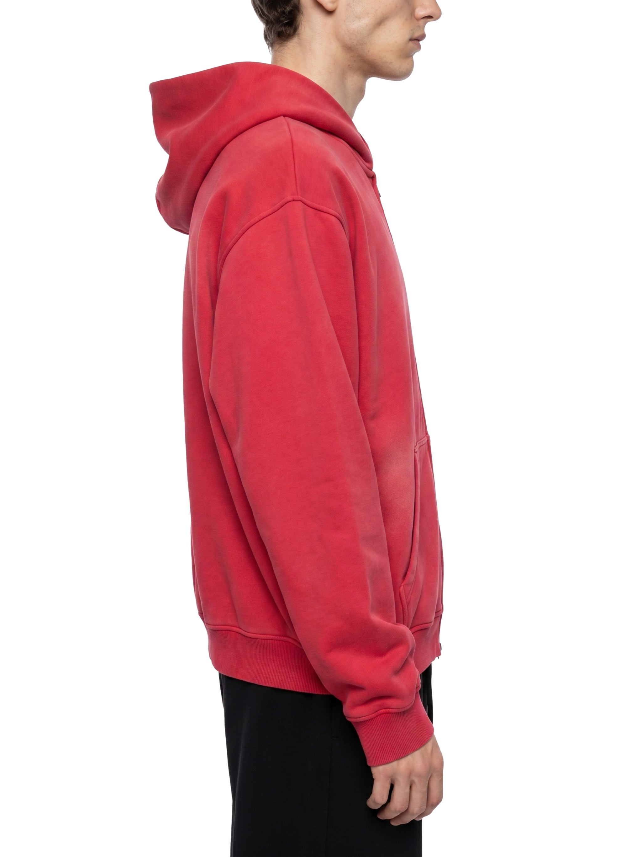 Side view of a man wearing a red sunfade boxy fleece hoodie with hood up.