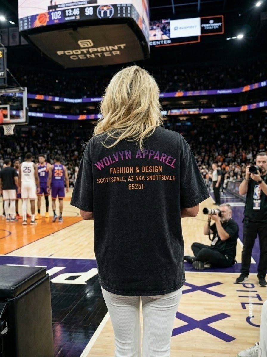 Person in vintage wash boxy t-shirt at basketball game, crowd and photographers visible