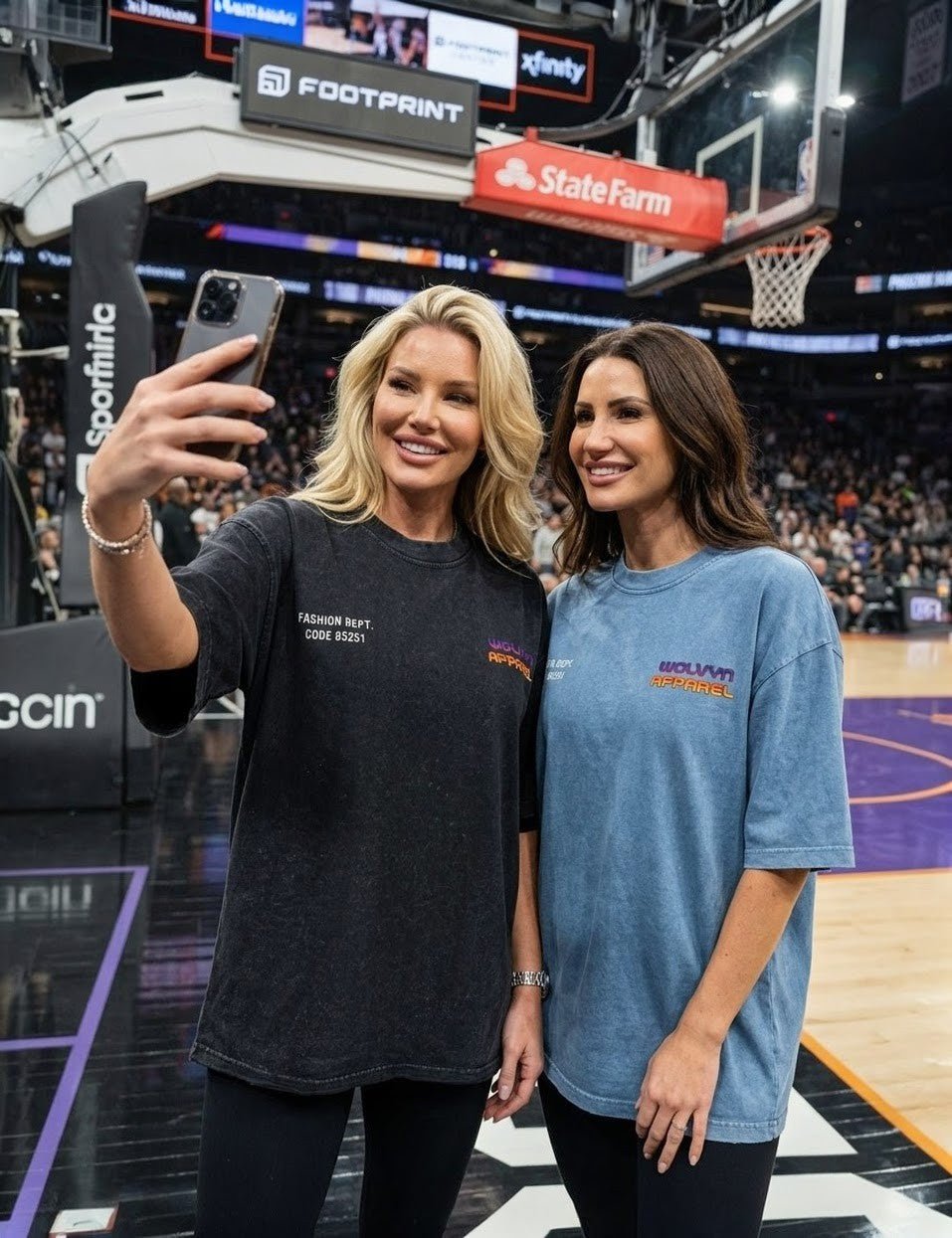 Two women wearing vintage wash boxy t-shirts take a selfie on a basketball court.