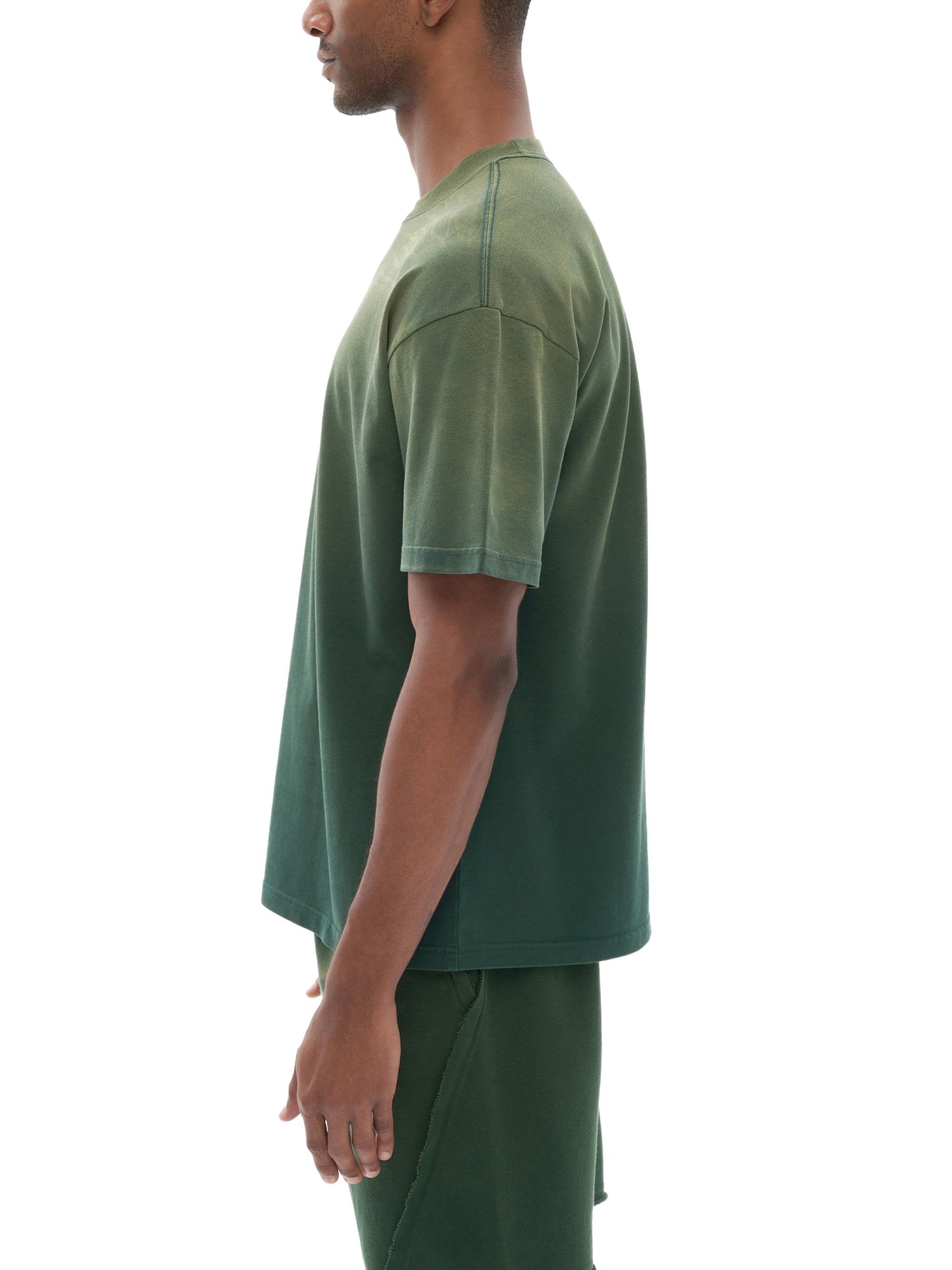Side view of man wearing green gradient washed t-shirt, modern streetwear style