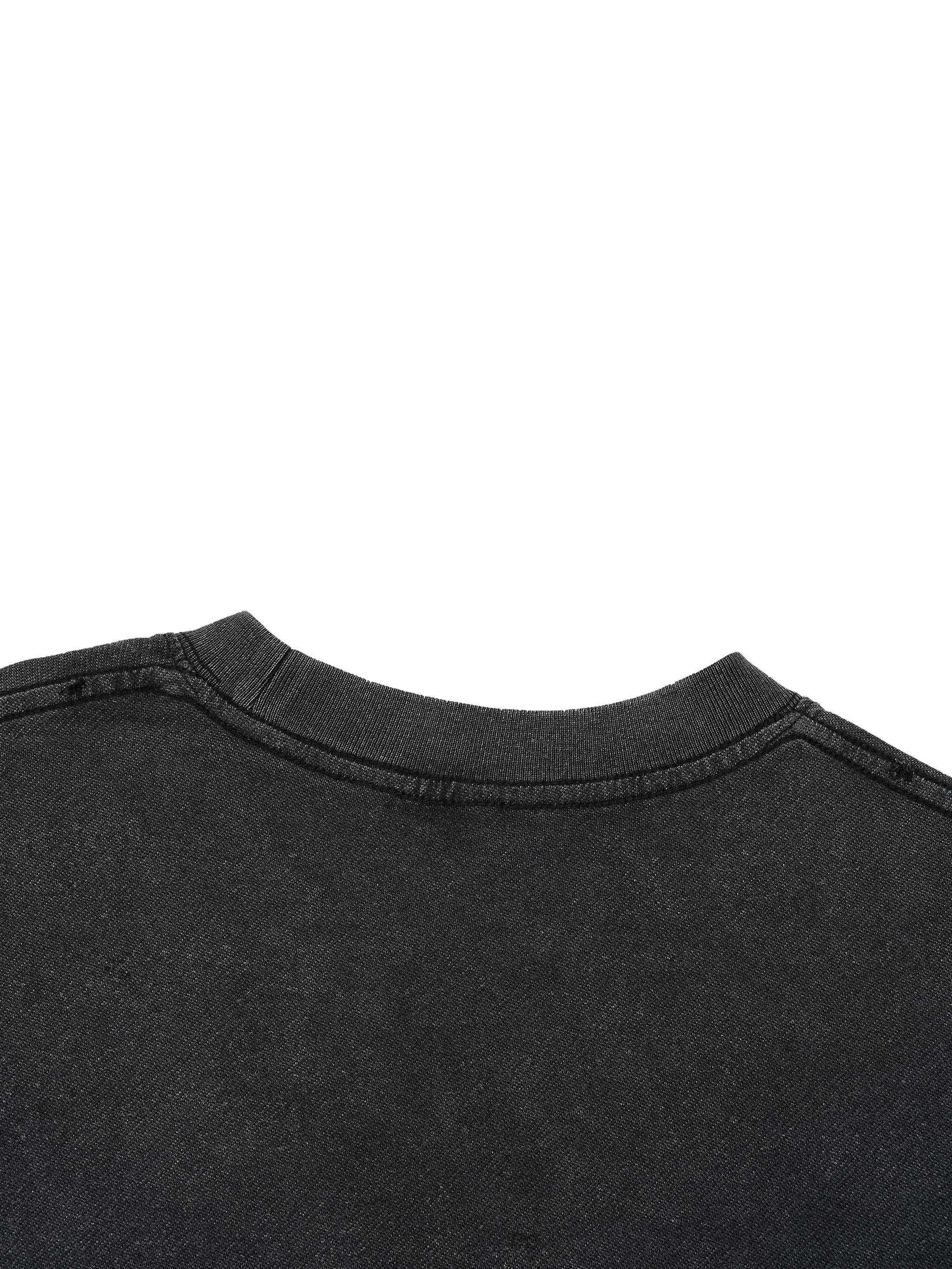 Close-up of black vintage wash t-shirt collar with distressed hem and heavyweight fabric