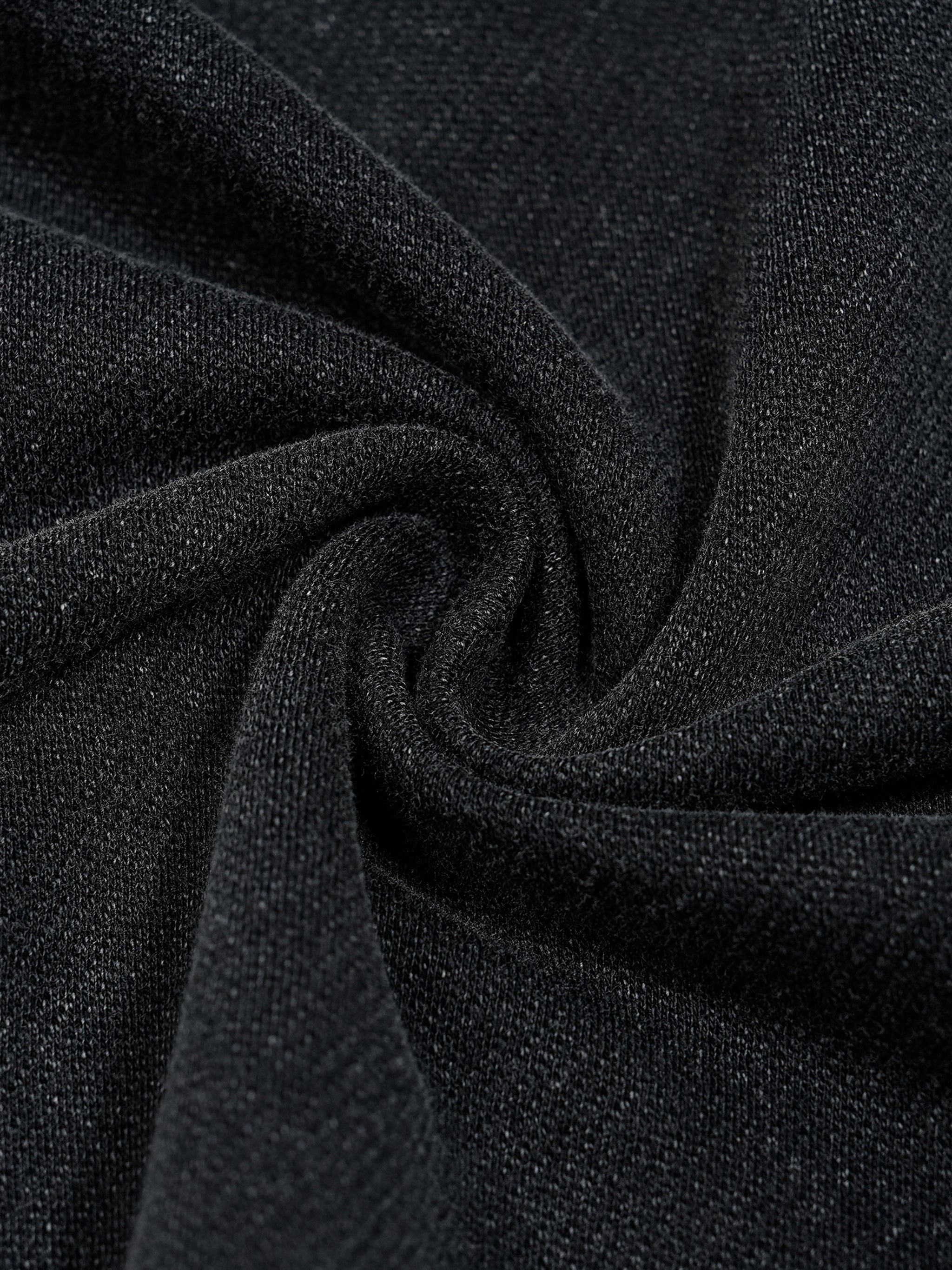 Close-up of black heavyweight streetwear fabric with vintage wash texture.