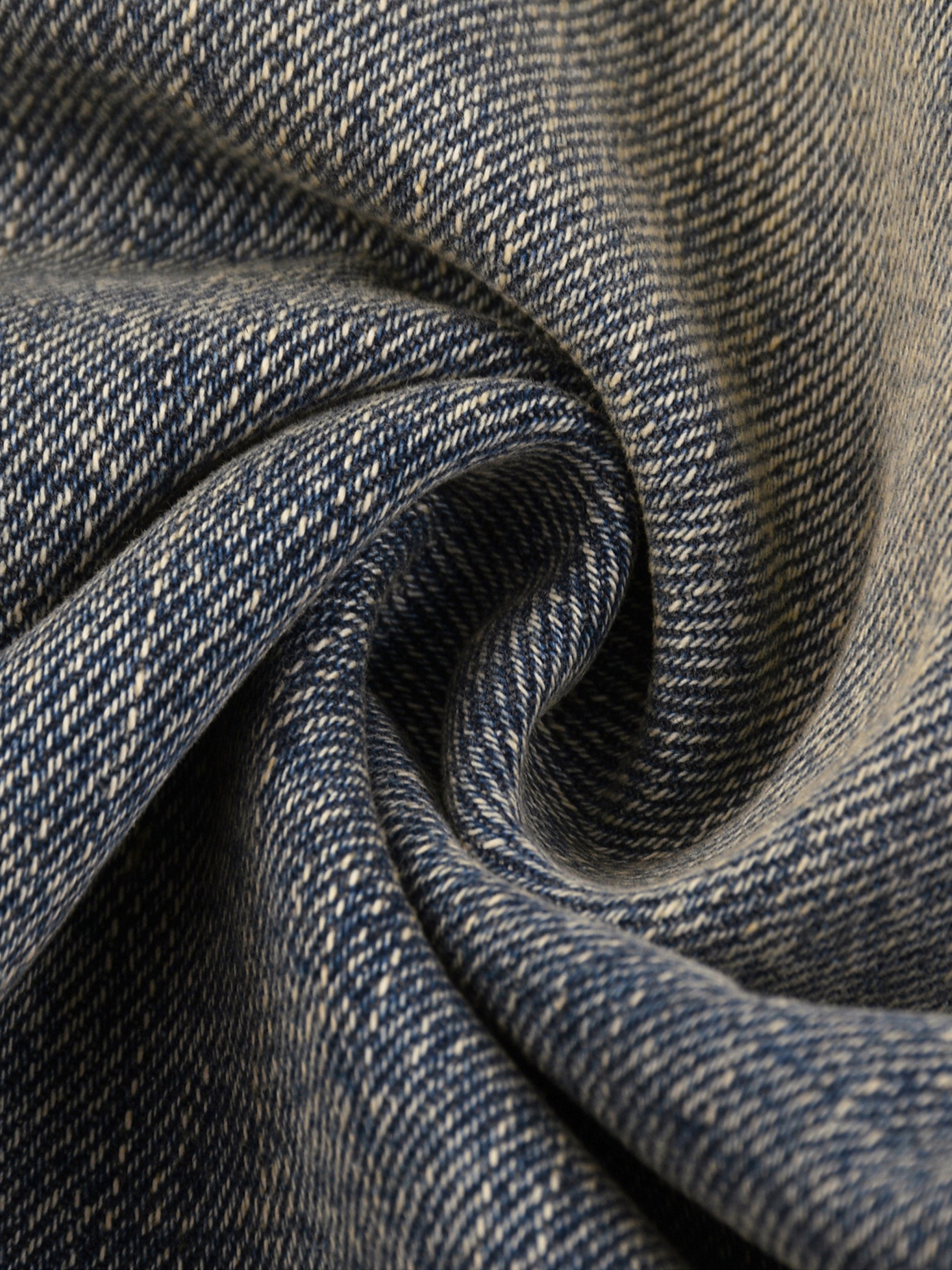 Close-up of blue vintage wash denim fabric with a textured, heavyweight weave.