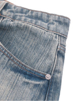 Close-up of vintage wash distressed denim jeans pocket with contrast stitching