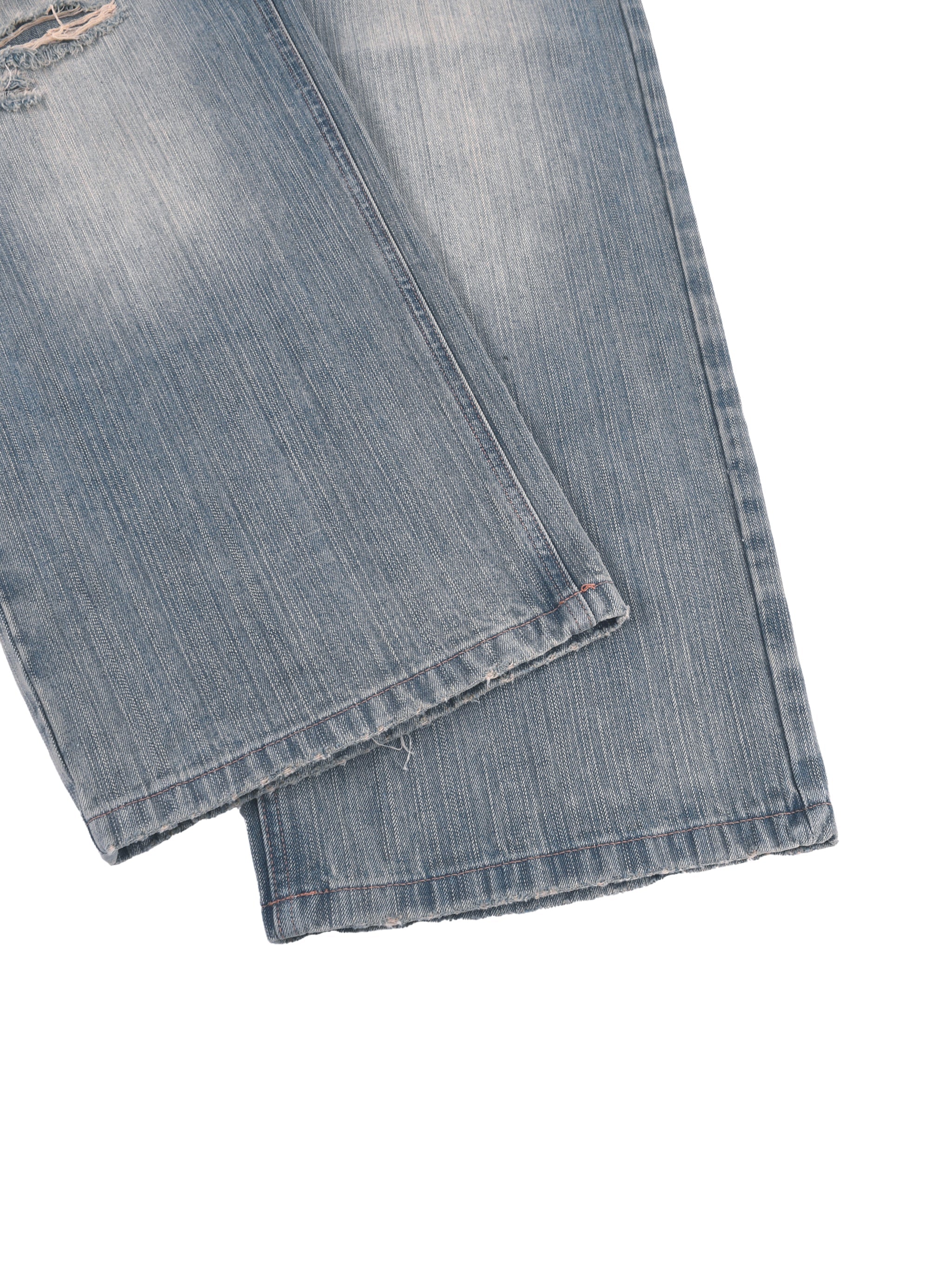 Vintage wash distressed denim jeans with subtle fraying at hems on white background