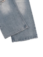Vintage wash distressed denim jeans with subtle fraying at hems on white background