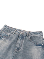 Vintage wash distressed denim jeans with classic five-pocket style on white background