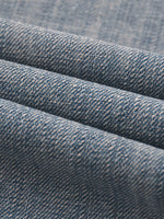 Close-up of blue vintage wash distressed denim fabric texture