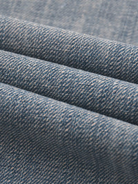 Close-up of blue vintage wash distressed denim fabric texture