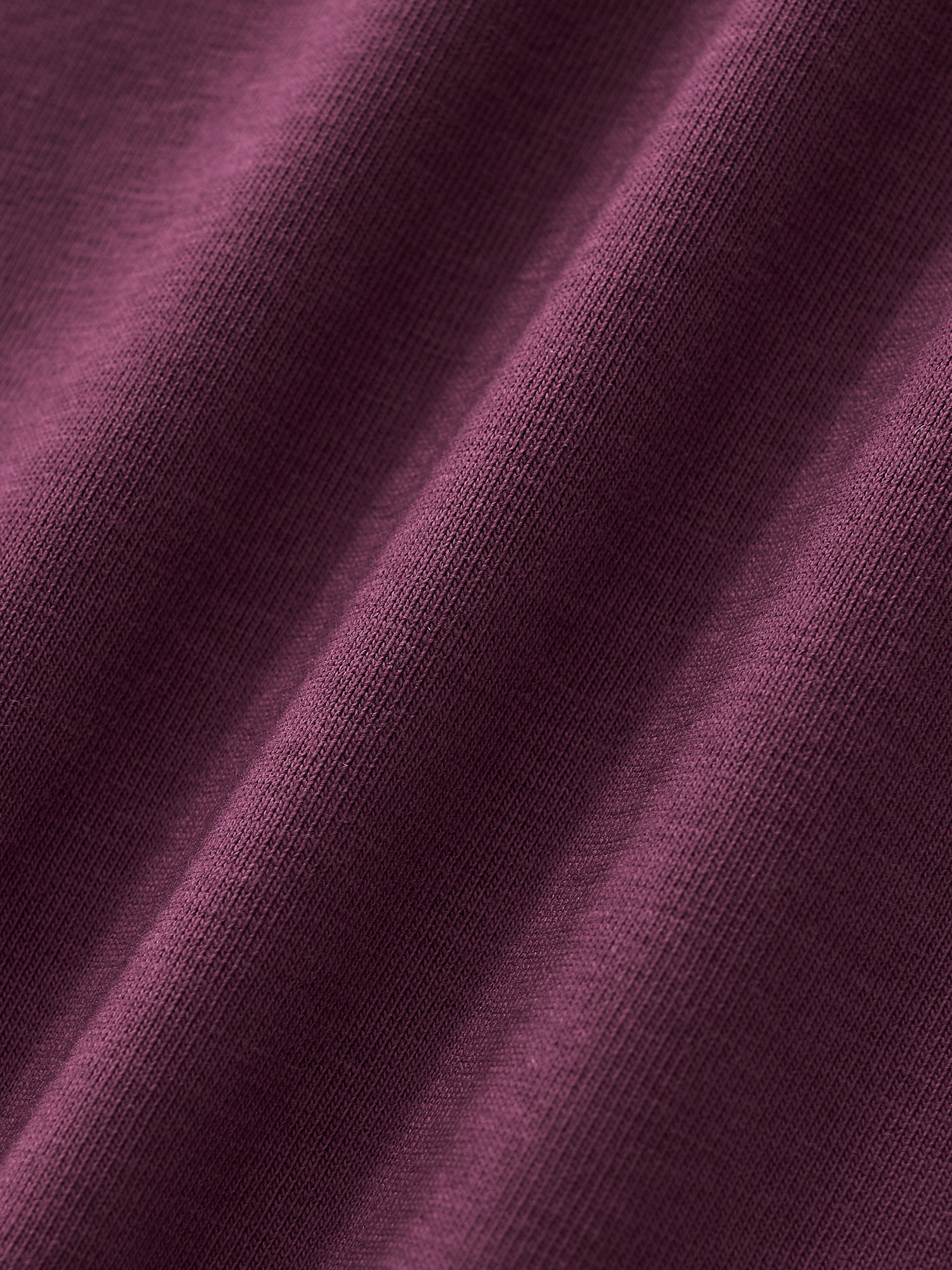 Close-up of maroon heavyweight cotton fabric with ribbed texture and natural drape