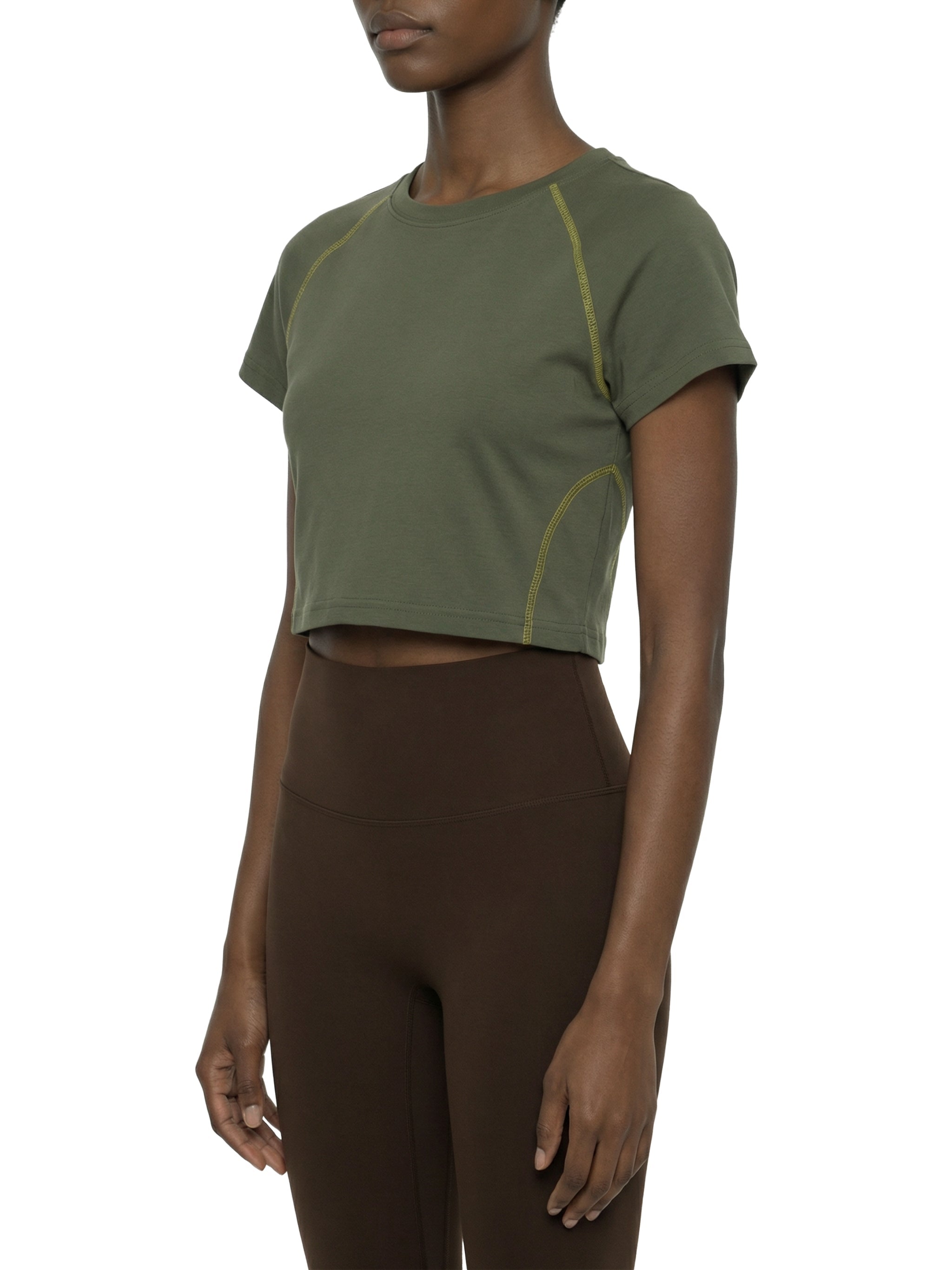 Woman wearing an olive green crop t-shirt with contrast yellow stitching and short sleeves