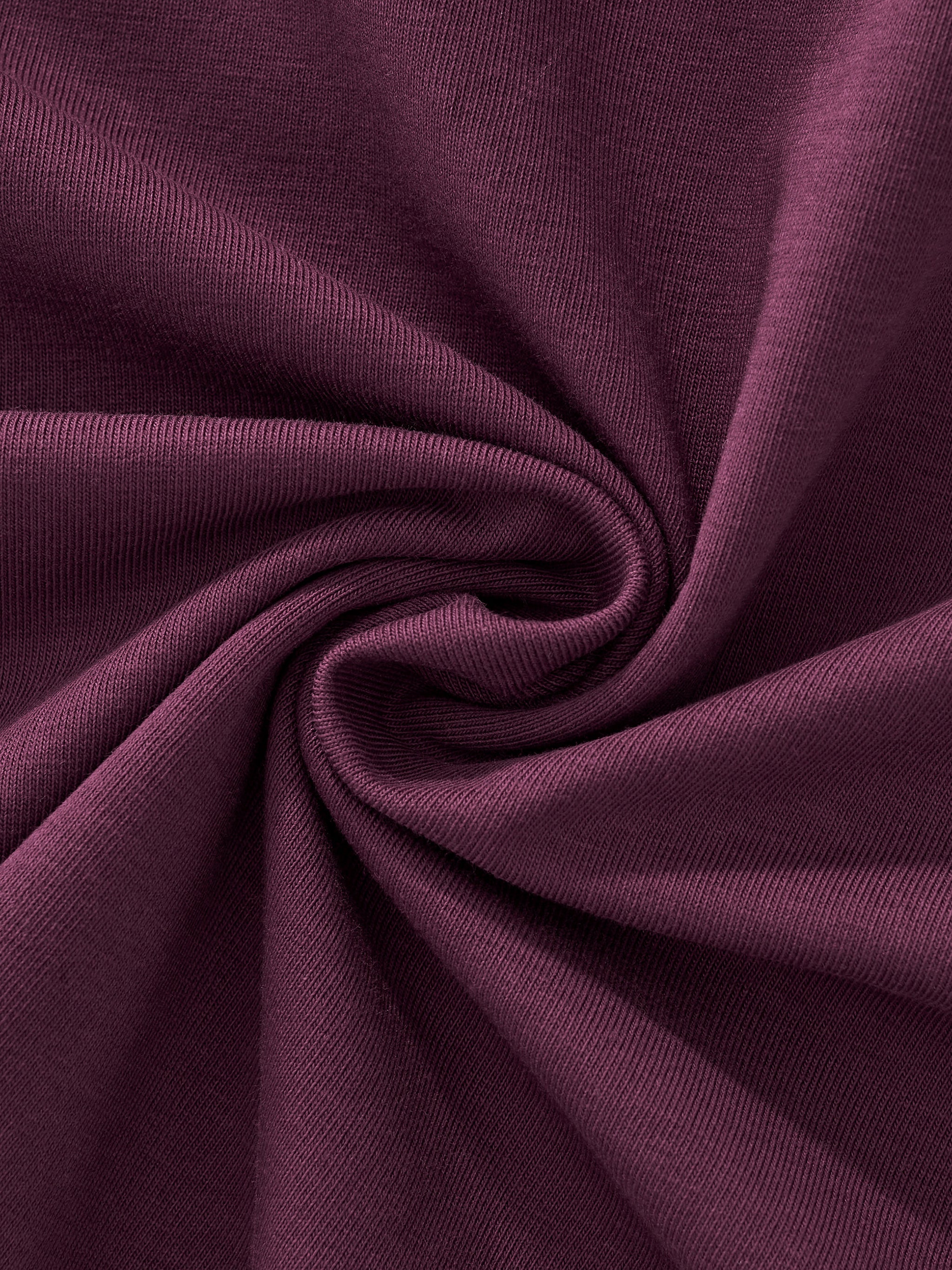 Close-up of soft, heavyweight purple knit fabric with fine ribbed texture, twisted in folds.