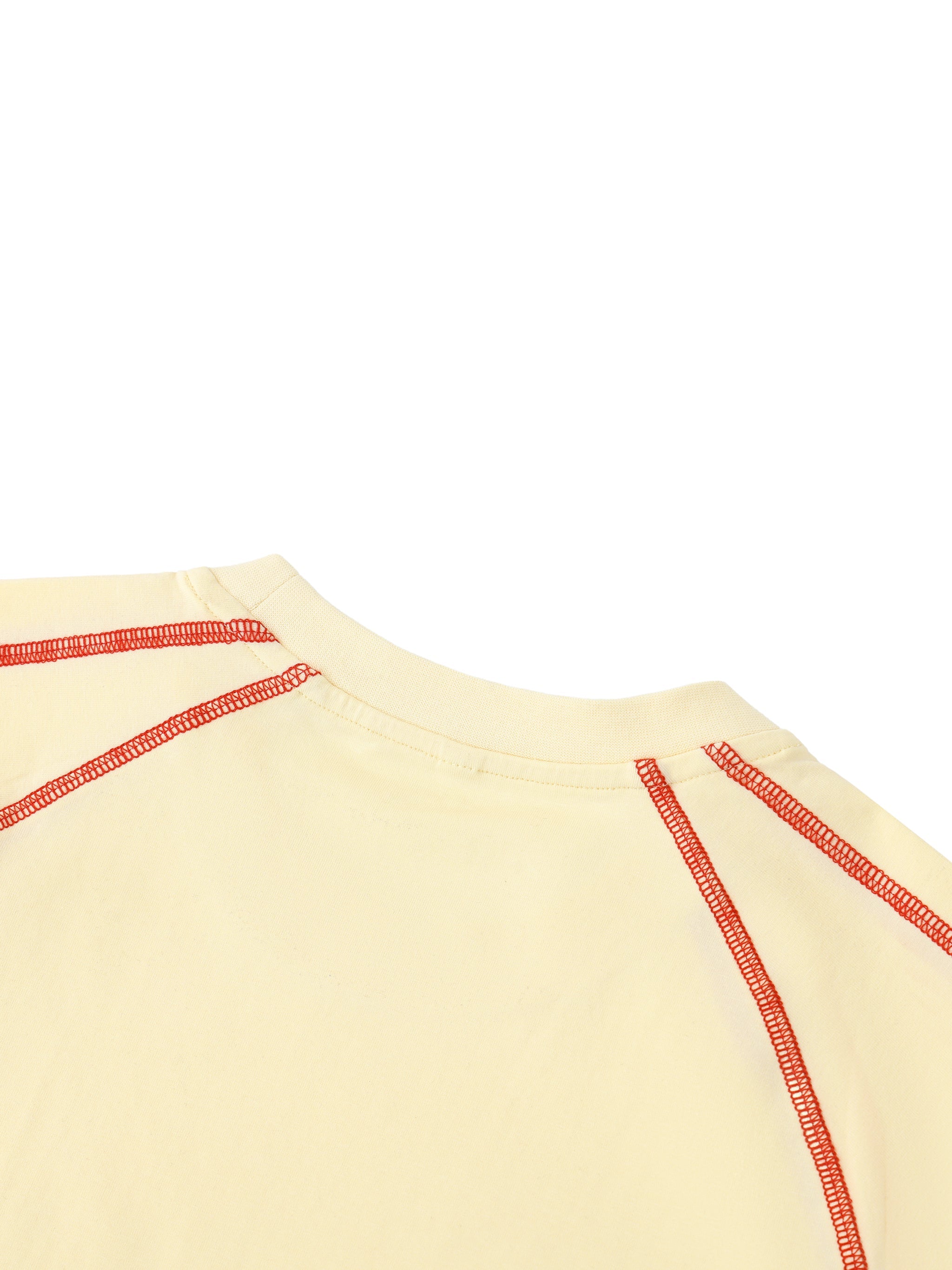 Close-up of women's cream raglan t-shirt with red contrast stitching on shoulders