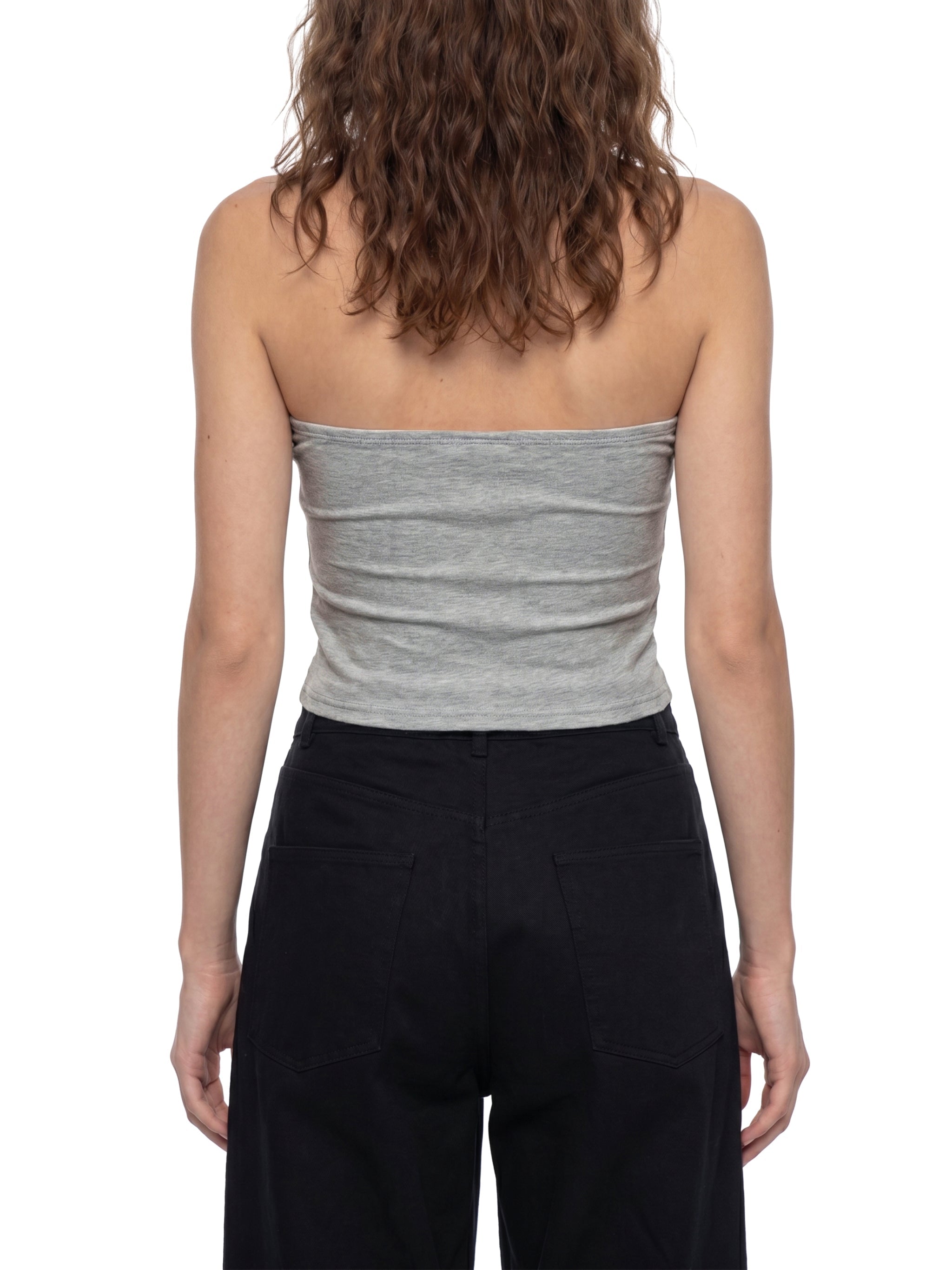 Back view of woman wearing a gray cropped tube top and black pants on white background