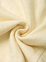 Close-up of soft, heavyweight cream fabric with textured knit pattern and gentle folds