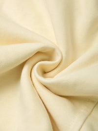 Close-up of soft, heavyweight cream fabric with textured knit pattern and gentle folds