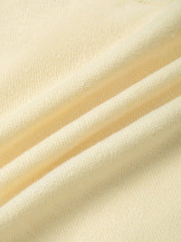 Close-up of soft, heavyweight cream knit fabric with textured surface and natural folds
