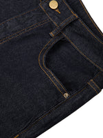 Close-up of women's high-rise skinny jeans in dark denim with gold stitching and rivets