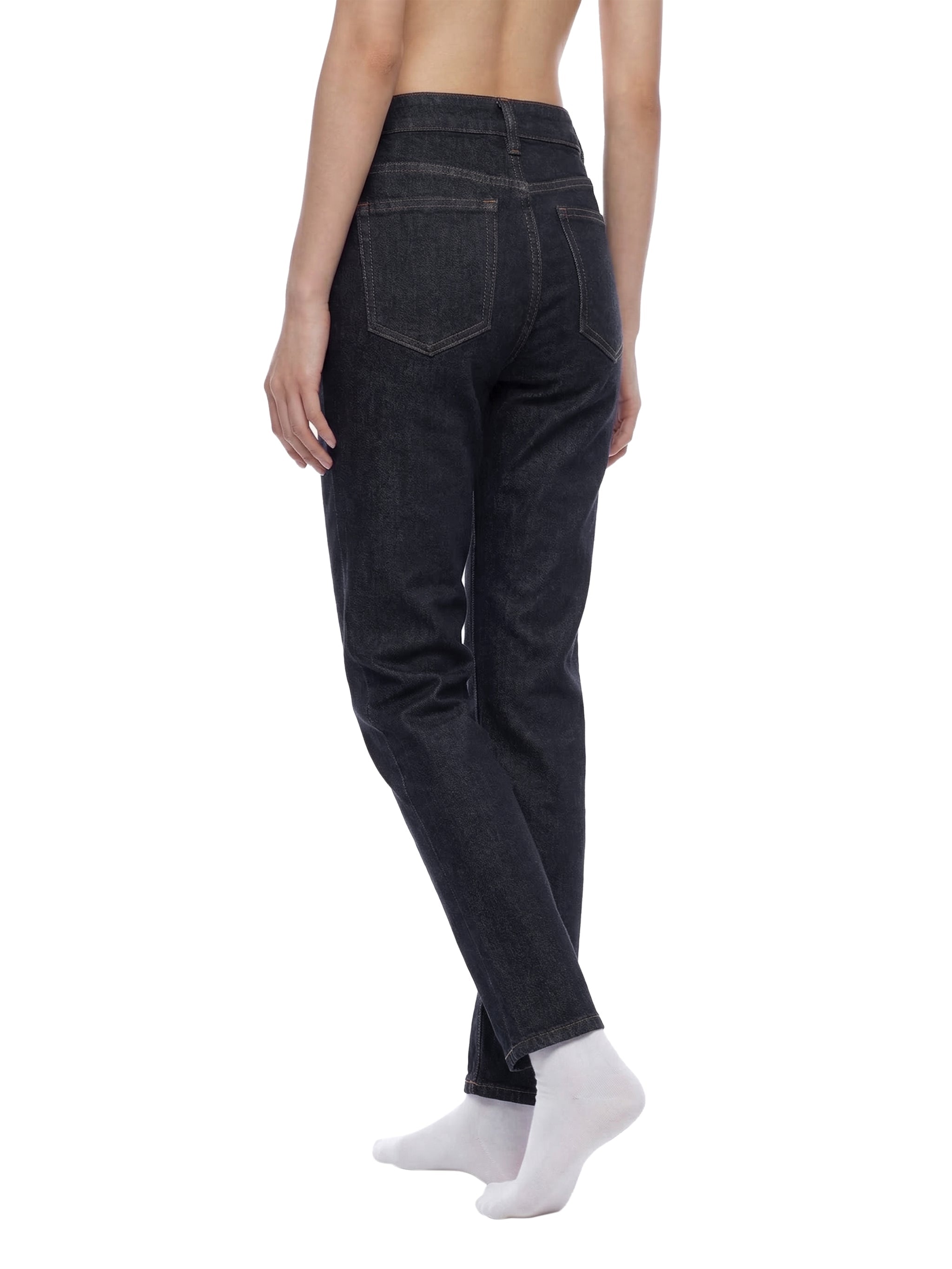 Woman modeling high-rise skinny jeans in dark blue denim, back view on white background