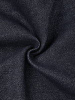 Close-up of dark blue denim fabric texture with visible weave, ideal for skinny jeans