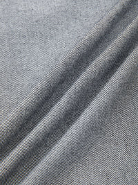 Close-up of light blue denim fabric texture with fine weave and soft folds